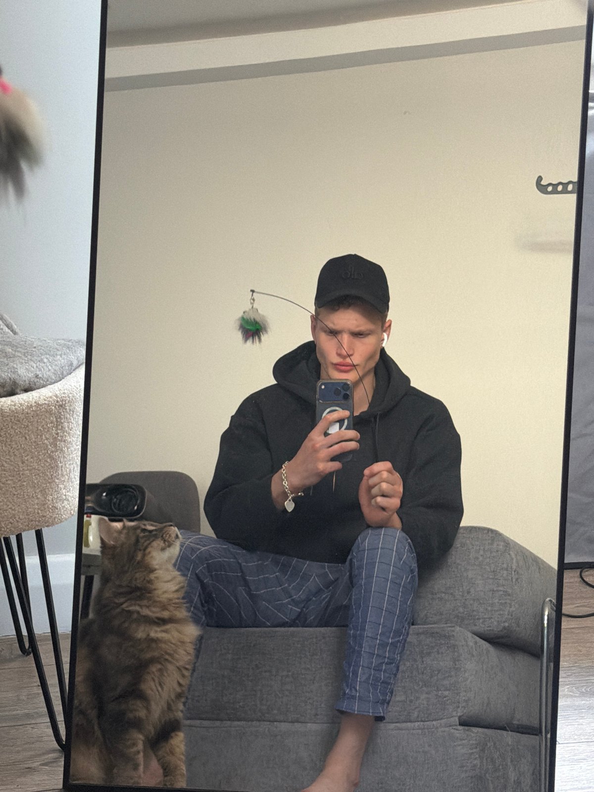 Man with cat captured in mirror reflection, London