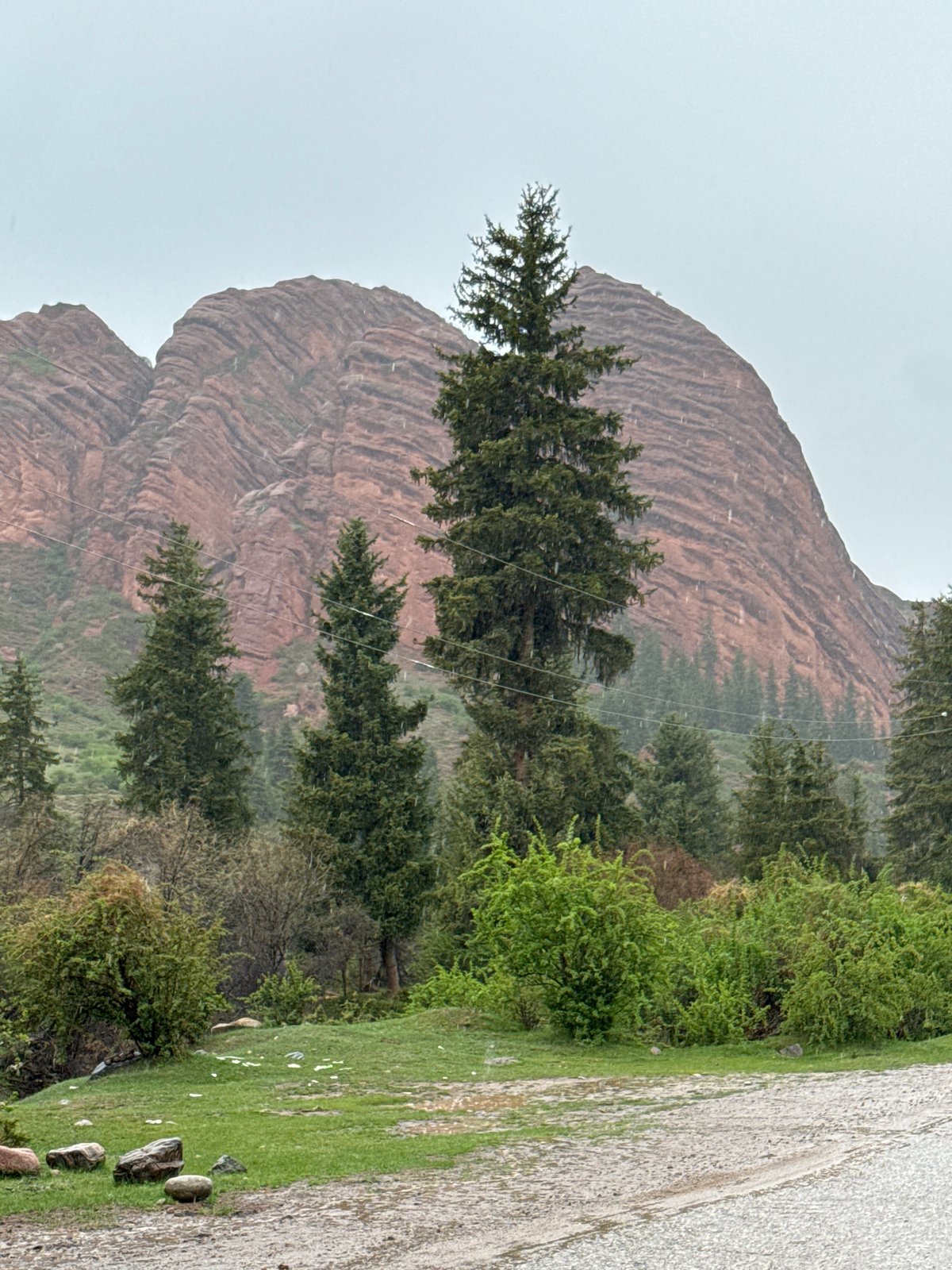 Tourist documents Kyrgyzstan mountain landscape after rainfall