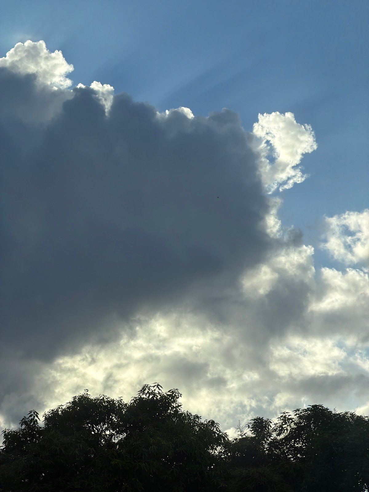 Dramatic sunbeams photographed through clouds in North Kuta, Indonesia