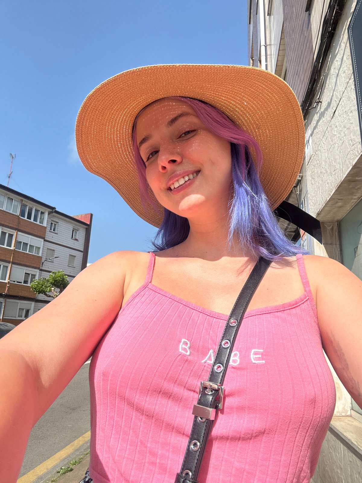 Woman in sun hat and pink top photographed in Gijón