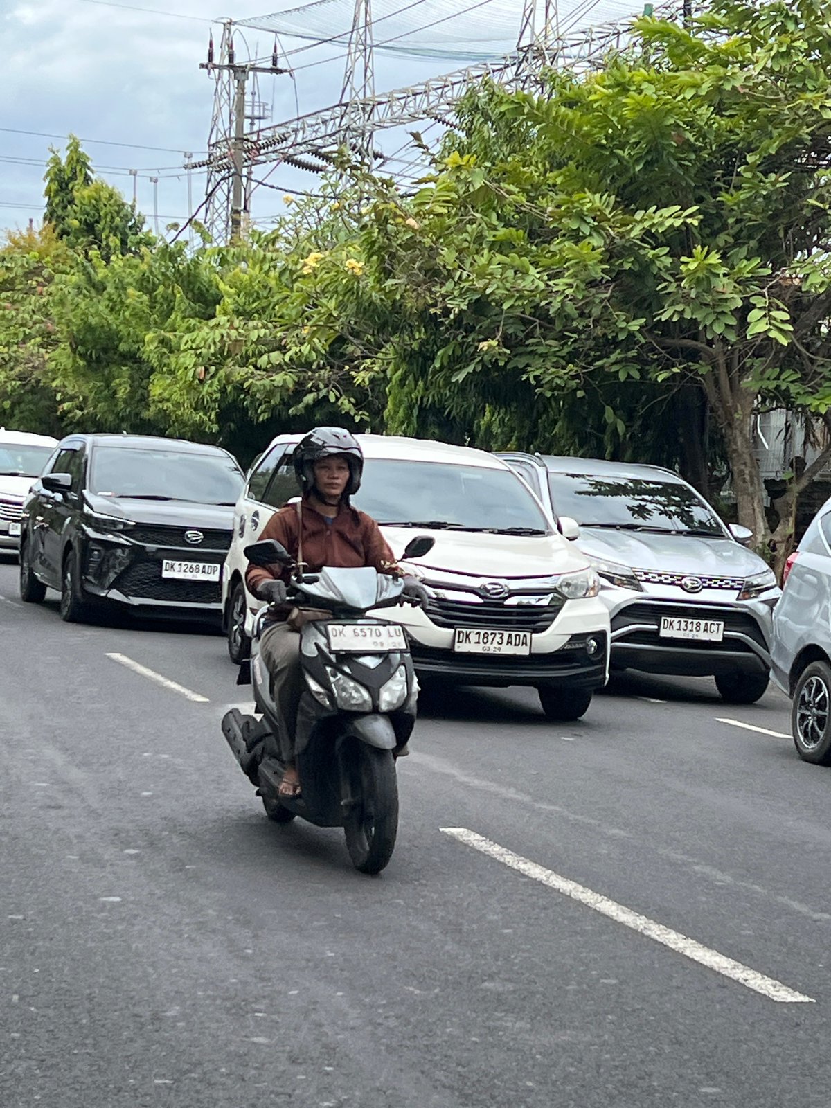 Morning scooter traffic flows through Denpasar streets