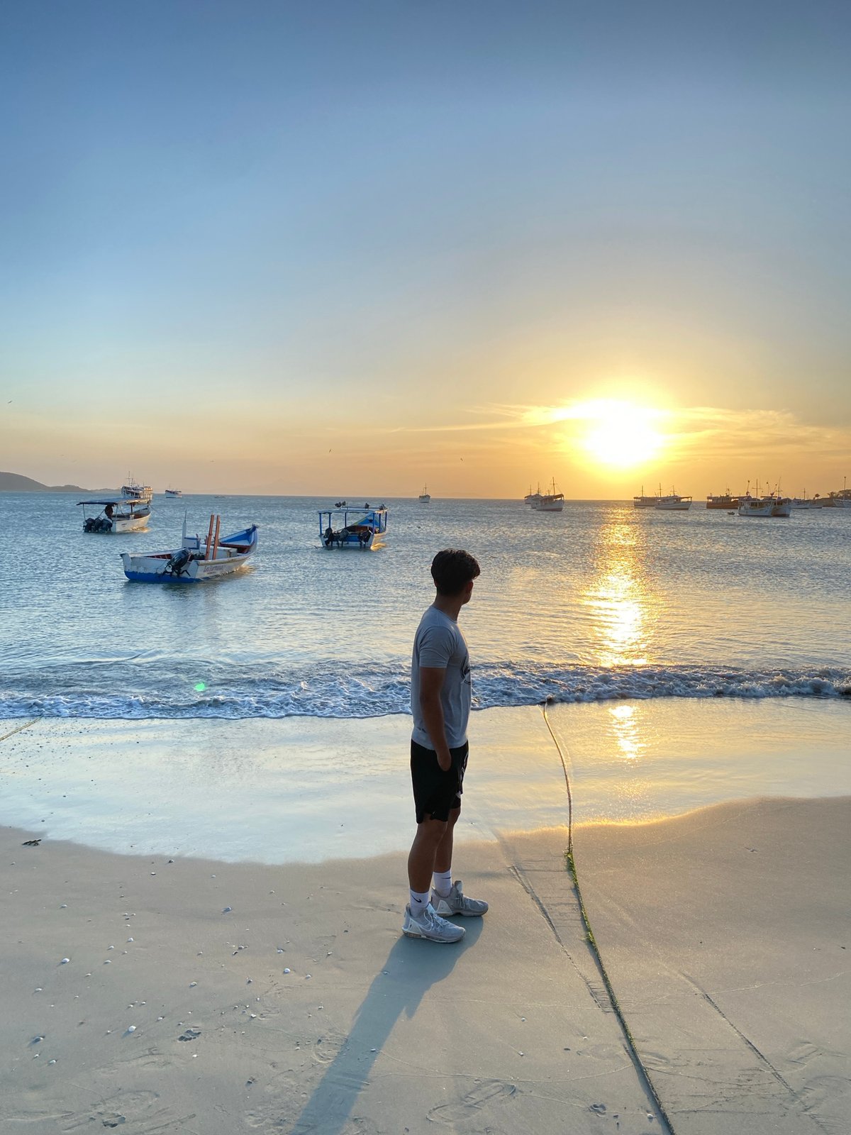 Man watches sunset from Juan Griego beach, Venezuela