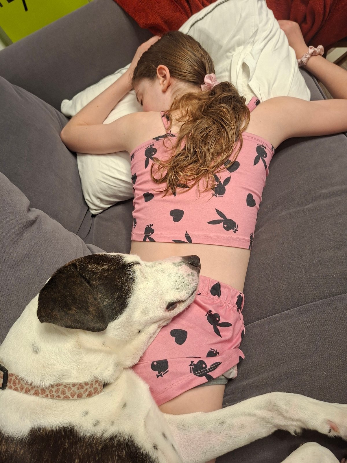 Person rests on couch in pink pajamas, Givatayim