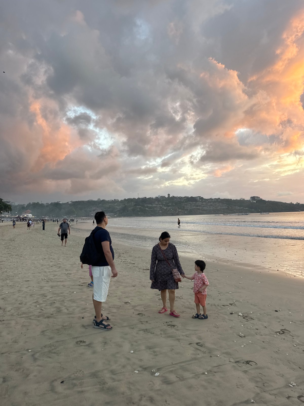 Kuta Selatan beach at sunset, people and horses on the shore