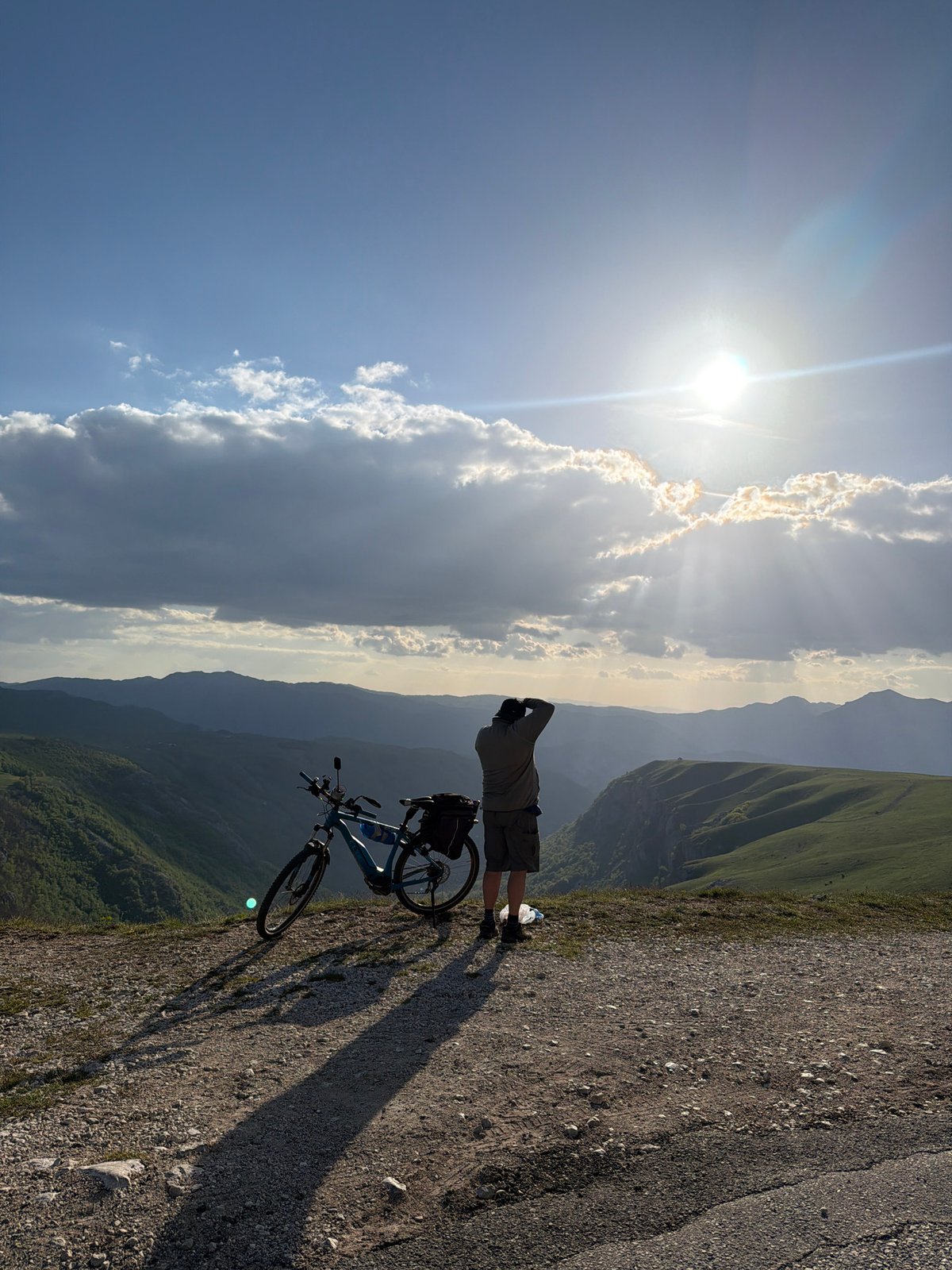 Cyclist pauses for mountain views in sunny Montenegro
