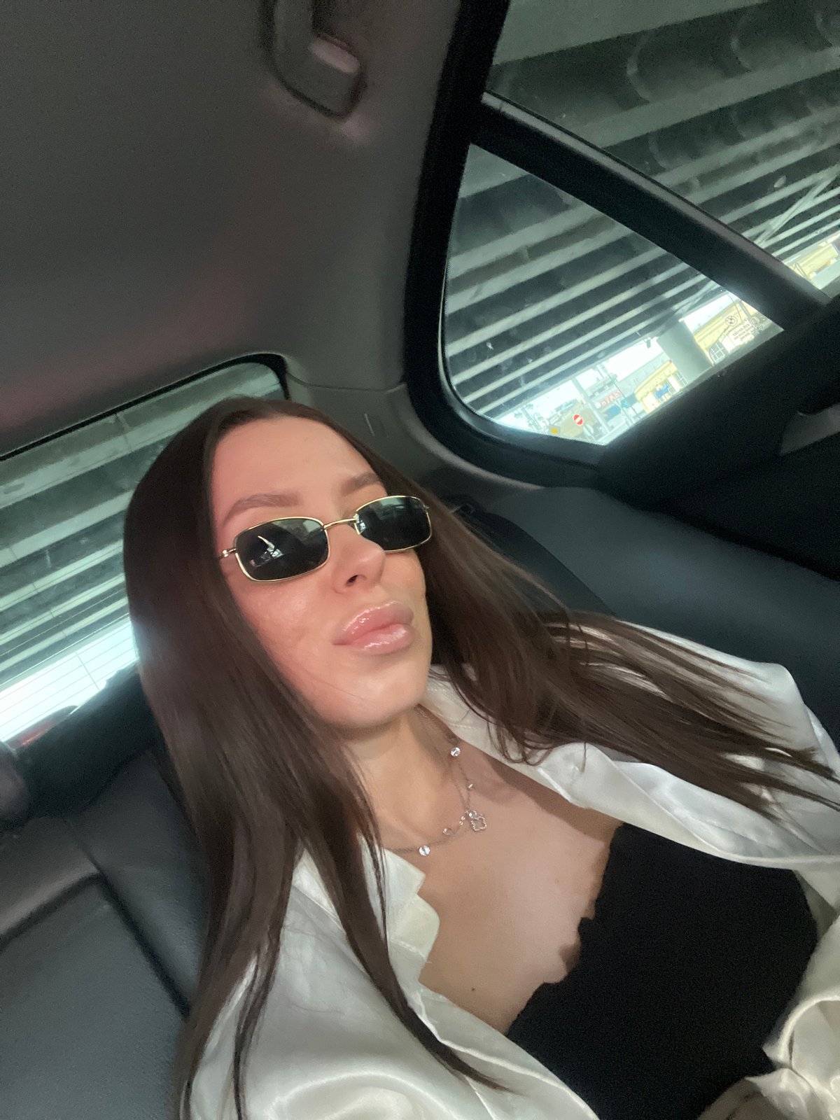 Woman in sunglasses observed in car backseat, Moscow