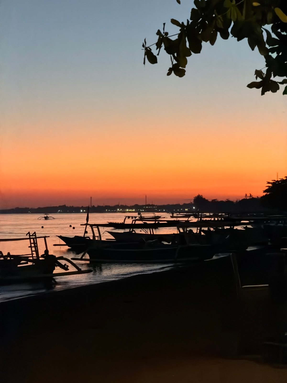 Fishing boats line the Buleleng shore at sunset