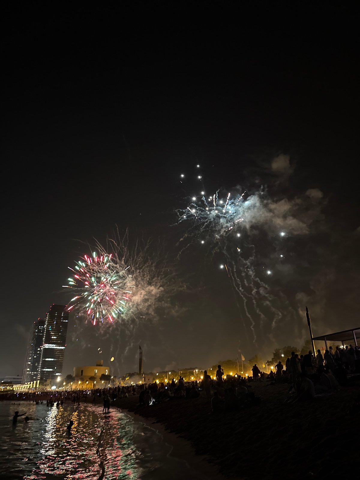 Barcelona's Sant Joan night: beach crowds, fireworks, sea.