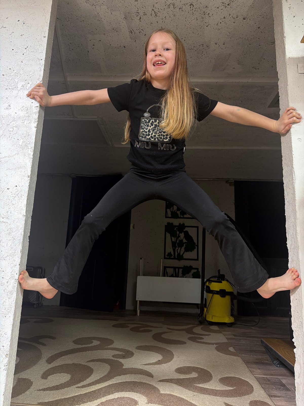 Girl playfully hangs upside down in building opening, Chaikovsky