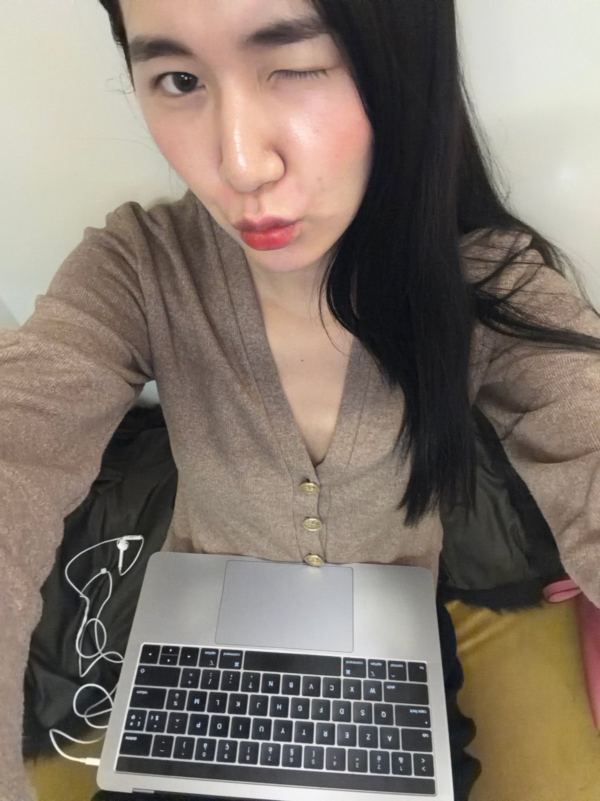 Person with laptop rests on cushioned surface in Paris