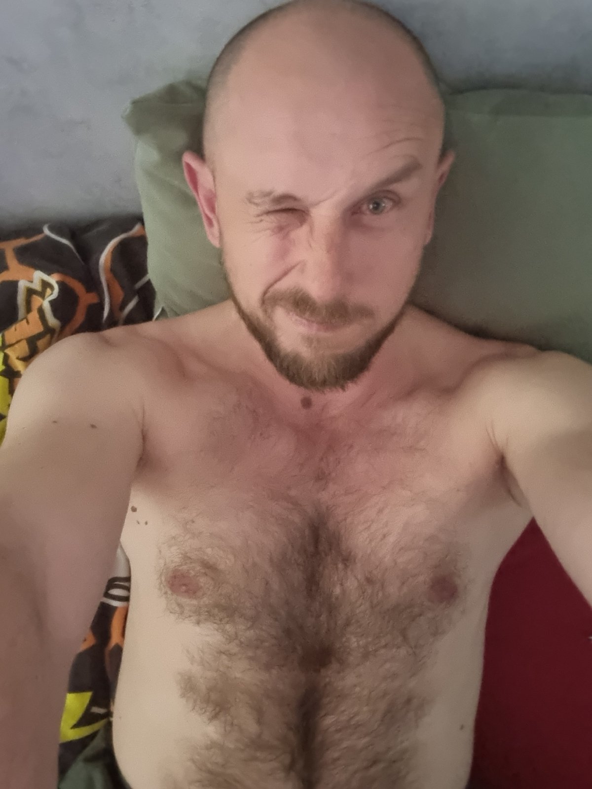 Two people rest on bed in Sochi apartment