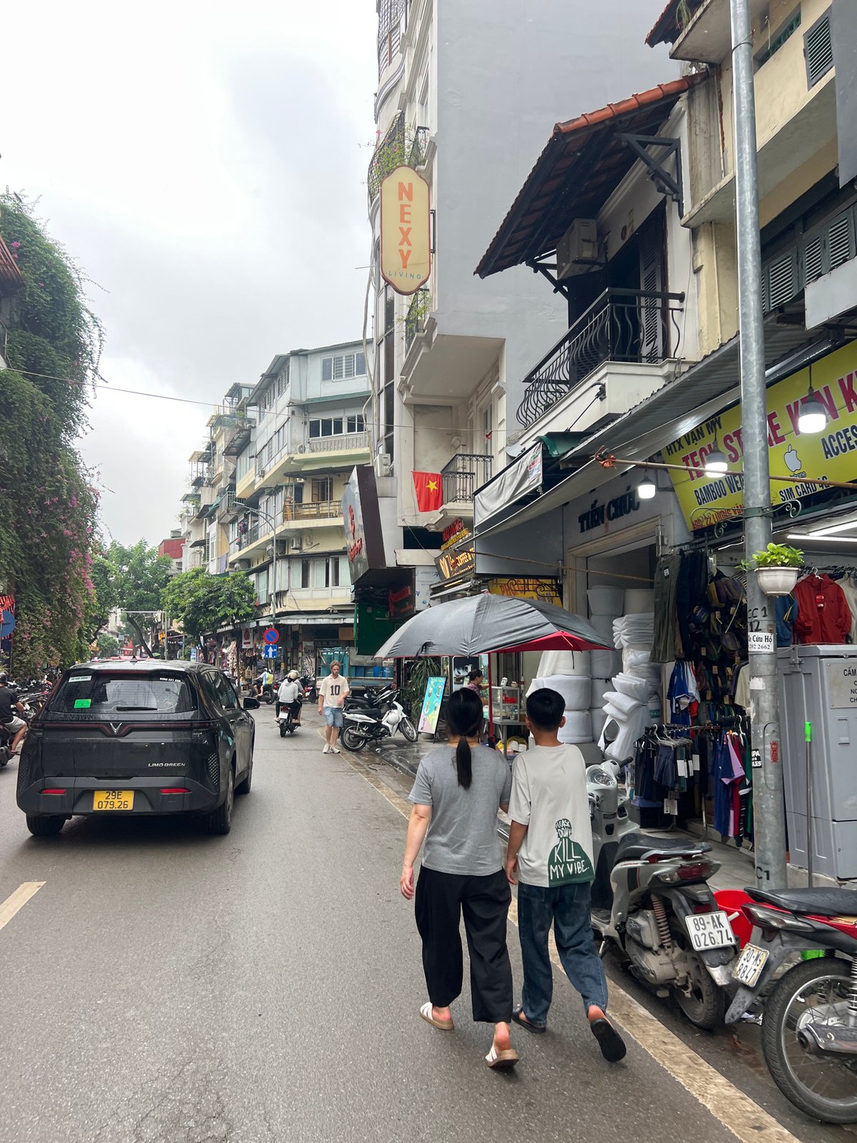 Cyclopousse and market stalls on a Hanoi street