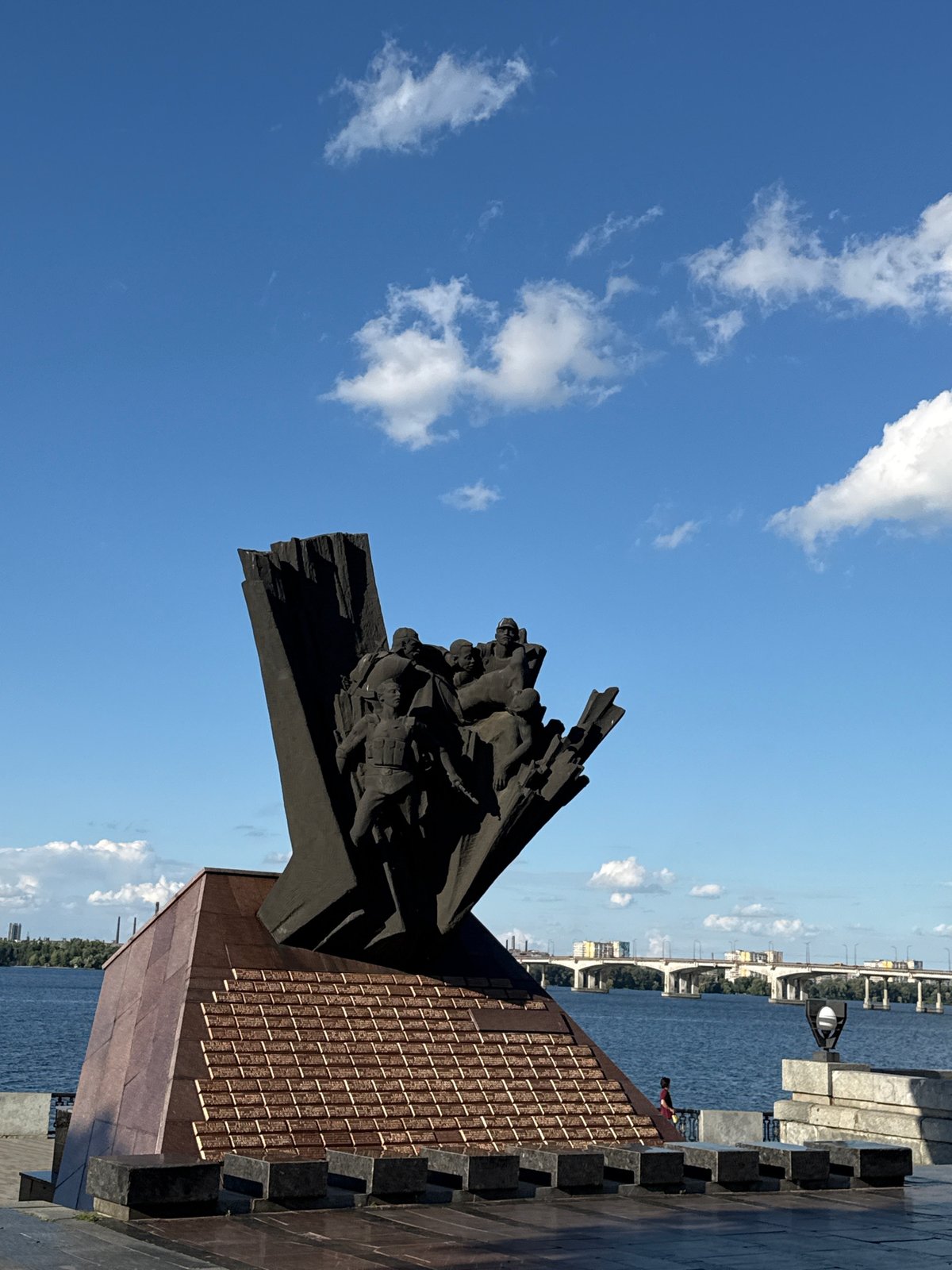 Monument and riverside bridge along the Dnipro waterfront