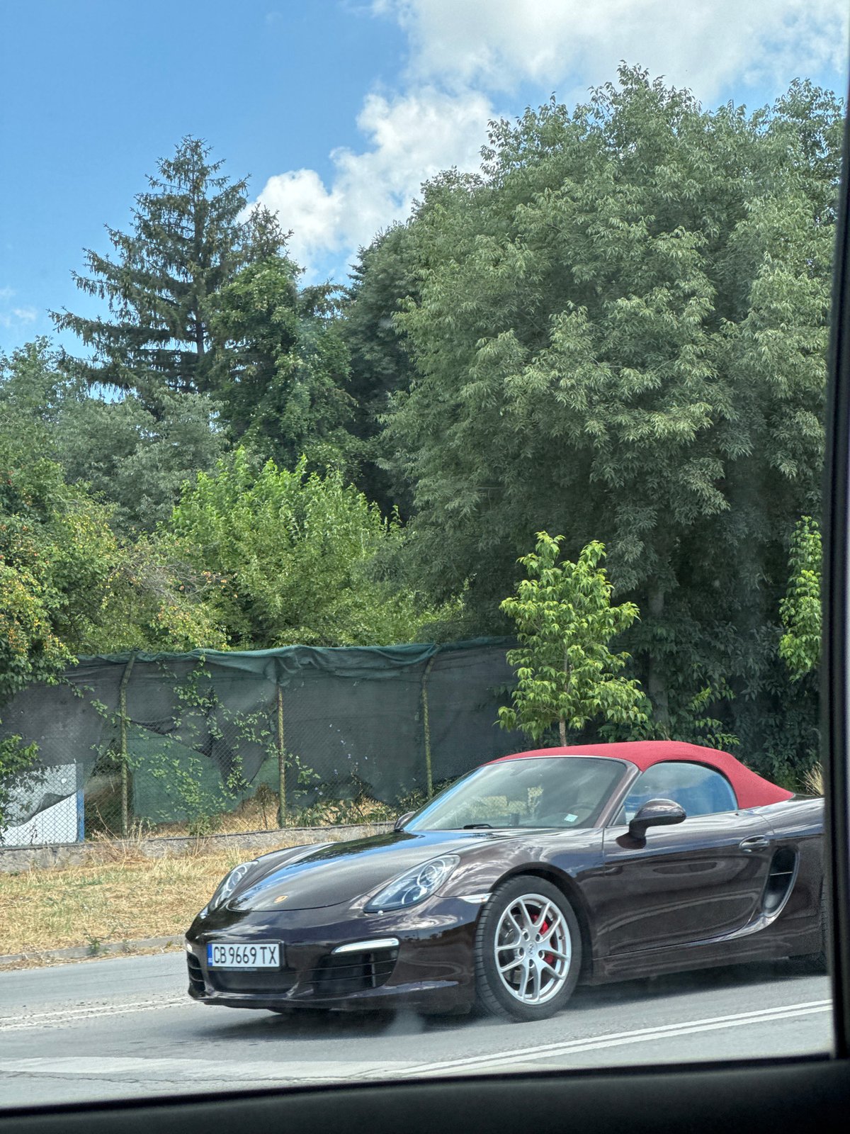 Dark brown Porsche Boxster with red top cruising through Varna