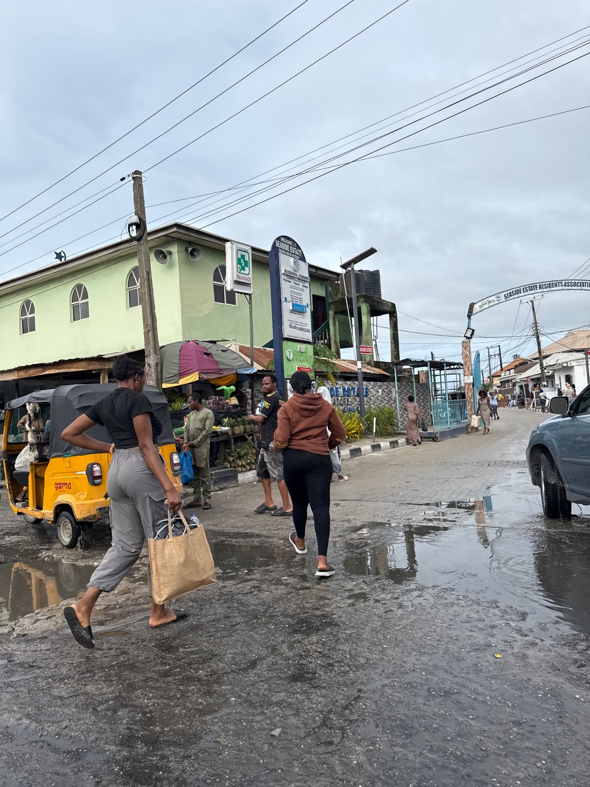 Pedestrians walk wet streets in Ado after rain