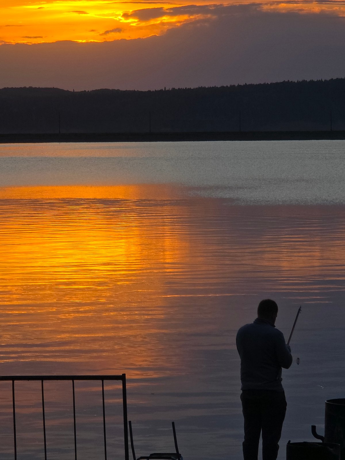 Sunset watchers gather along Chaikovsky waterfront during golden hour