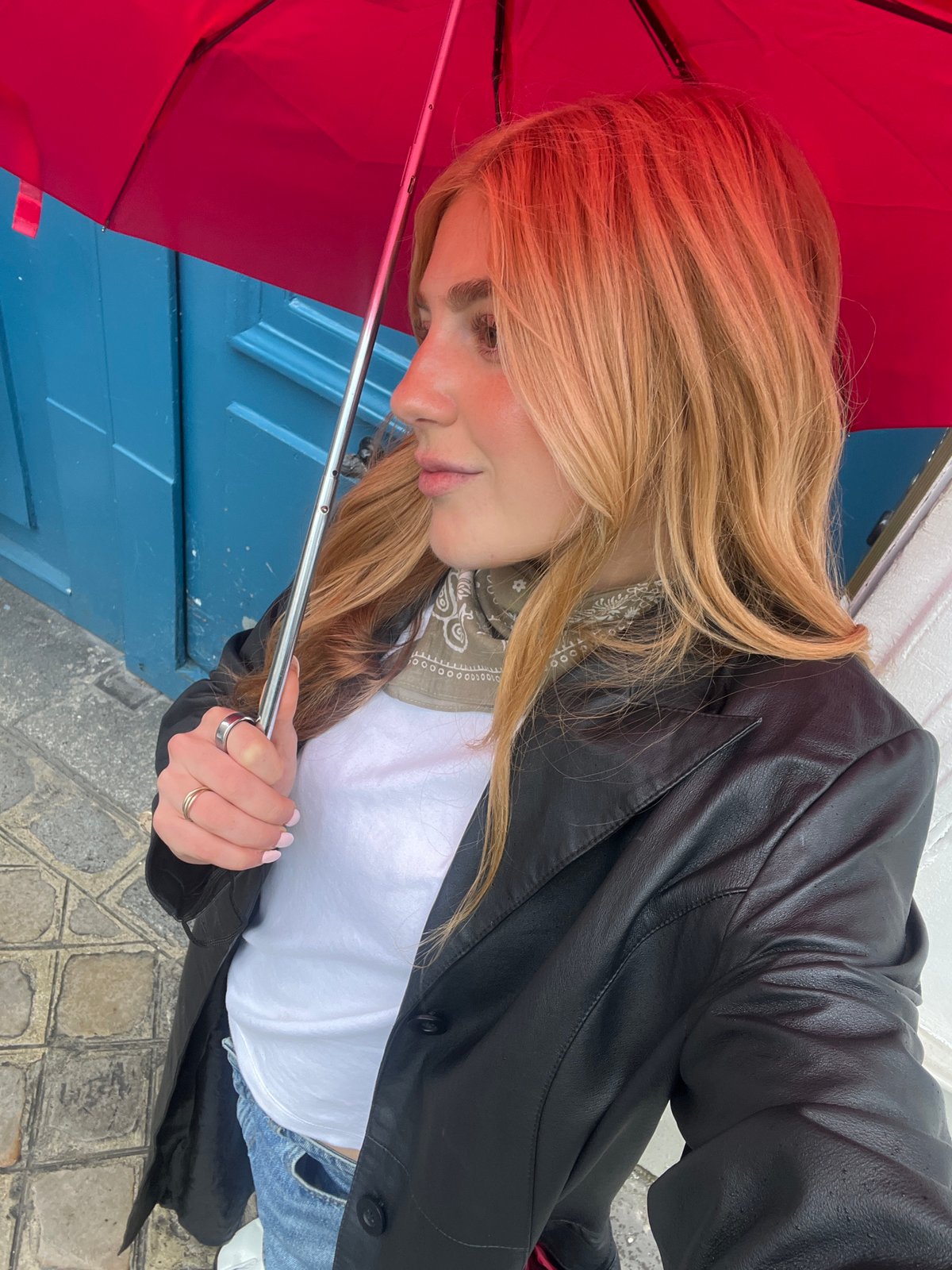 Person with red umbrella spotted at blue door in Paris