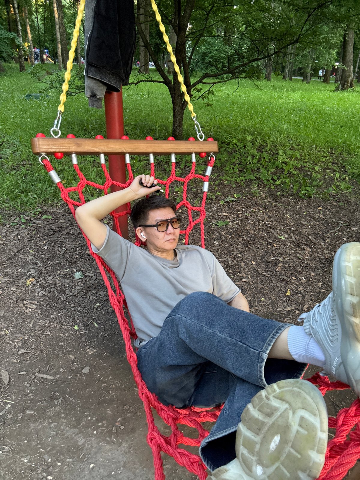 Man relaxes in red hammock at Moscow park