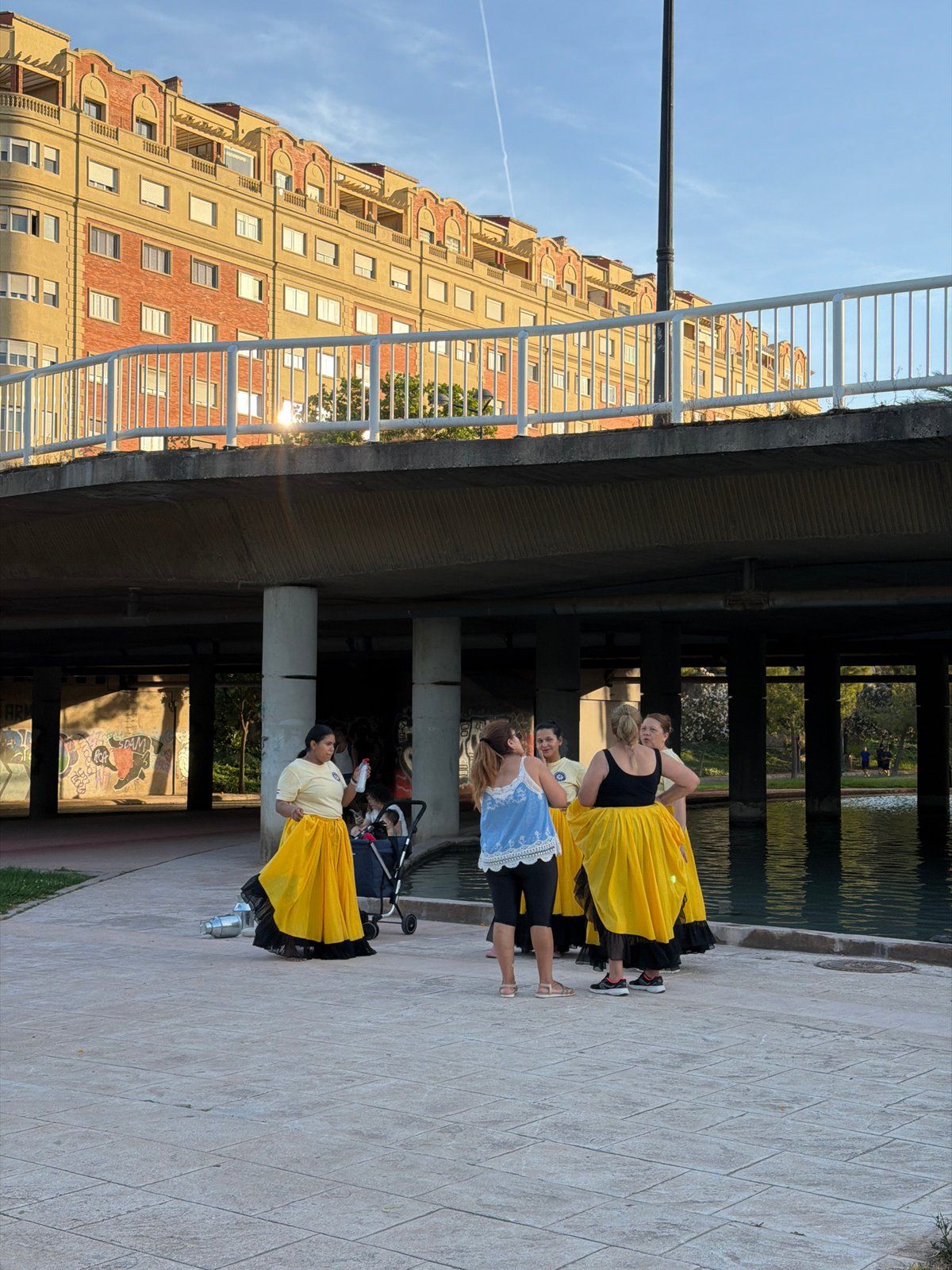 Traditional folk dancers perform with containers across Valencia parks