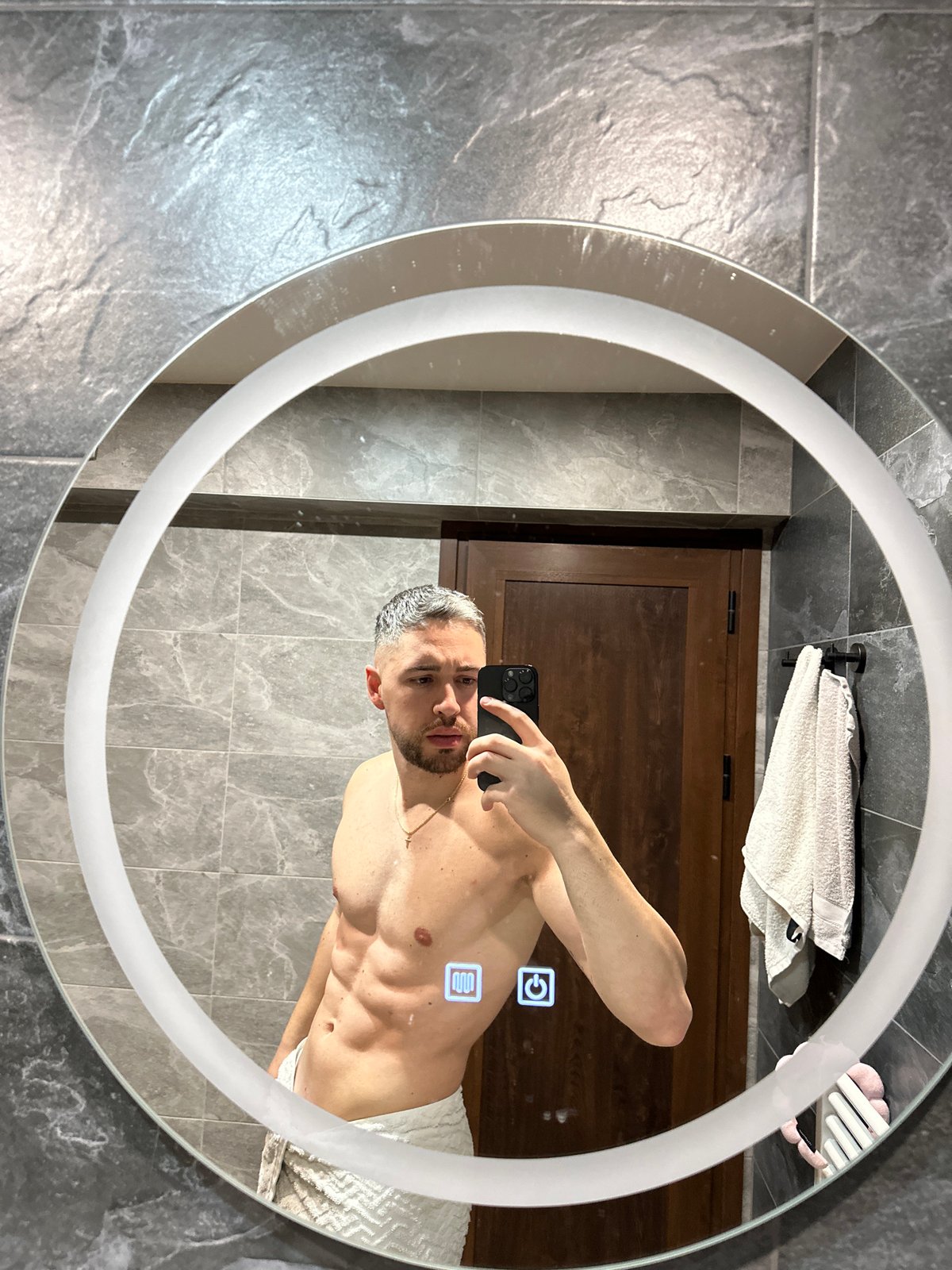 Man Takes Bathroom Mirror Selfie in Gray Tiled Modern Bathroom