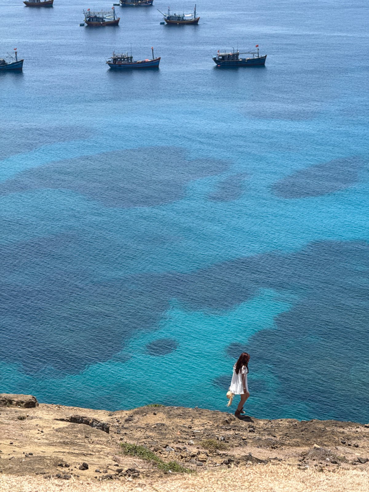 Clifftop views and fishing boats off Lý Sơn Island, Vietnam