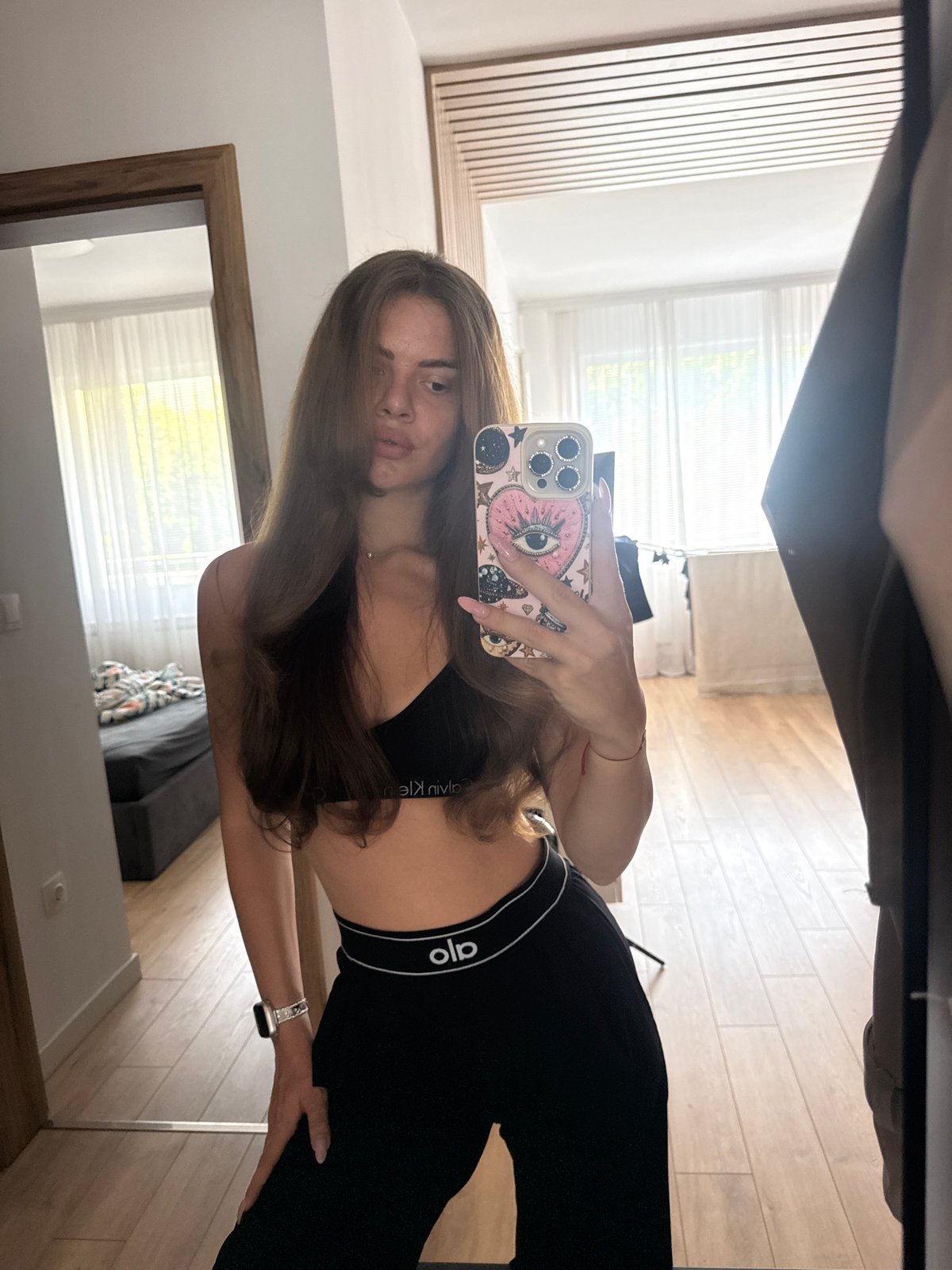 Woman takes mirror selfie in Calvin Klein sportswear