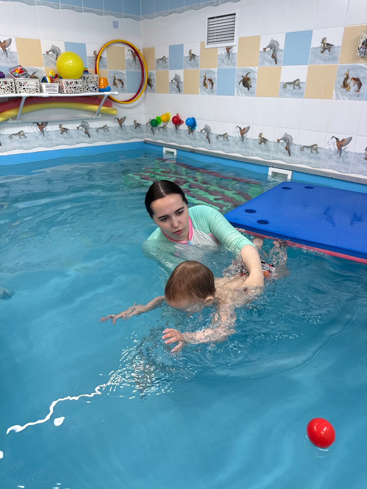Woman teaches child to swim in Rusanovo pool