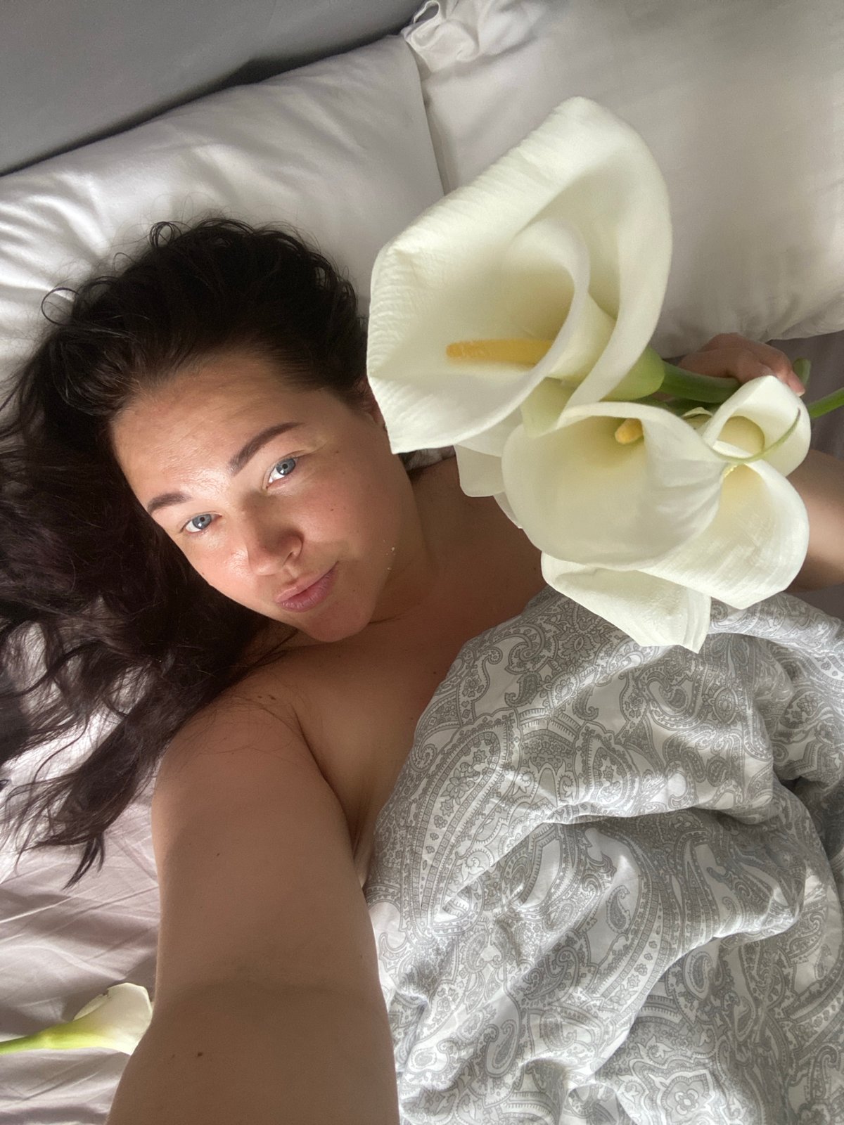 Woman photographs morning moments with flowers in Sochi bedroom