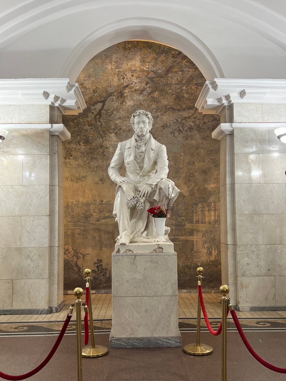 Pushkin statue observed with landscape mural backdrop in Saint Petersburg