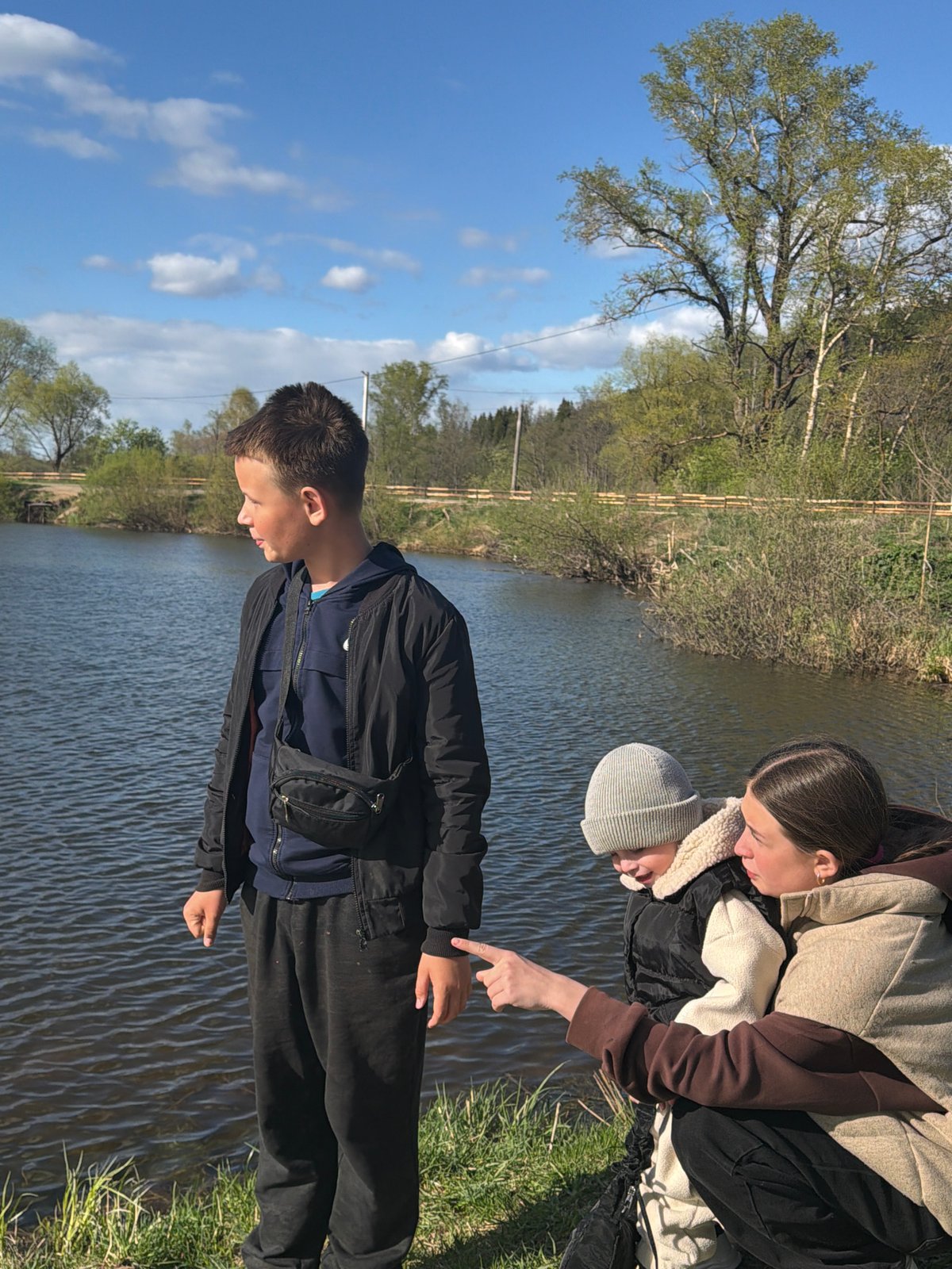 Family watches swans during lakeside outing in Bolshoy Bukor