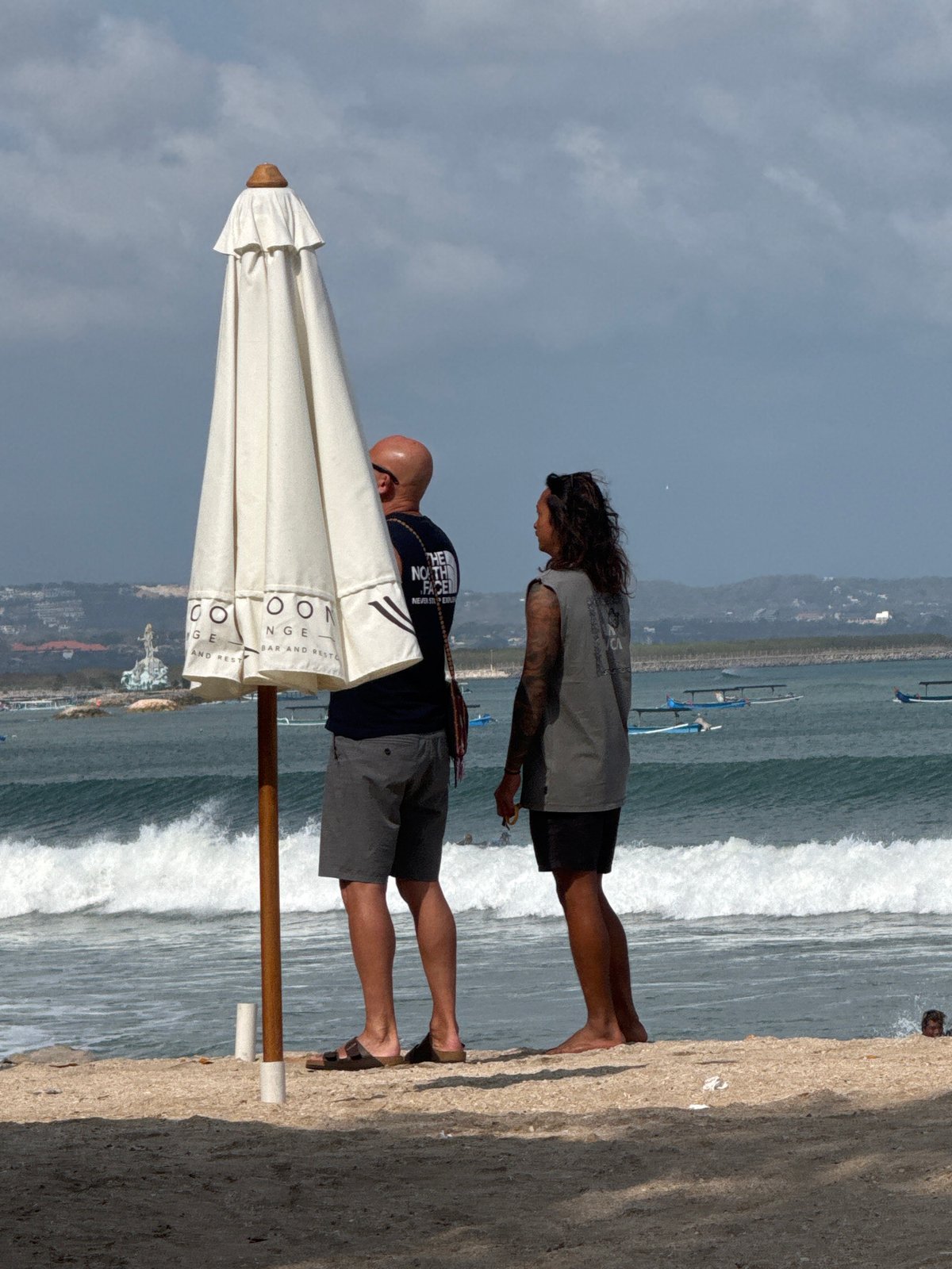 Kuta Beach in full swing: surfers, sunbathers, and shoreline activity