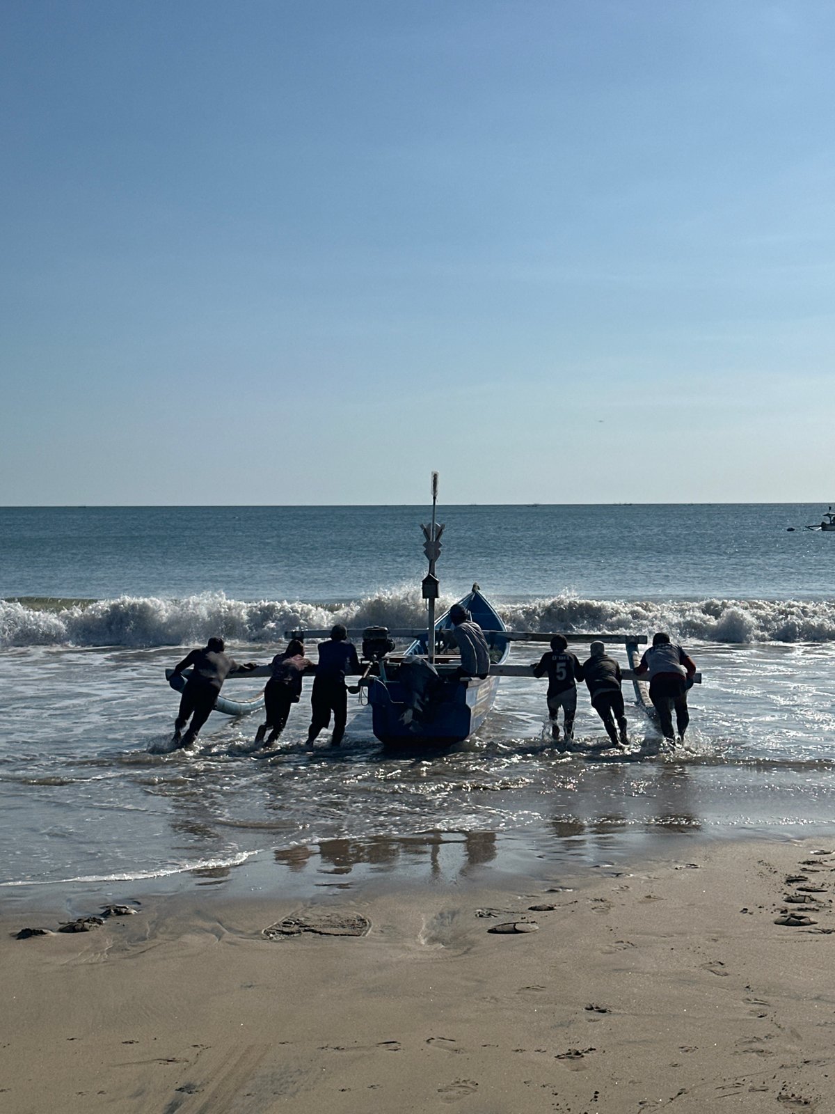 Traditional fishing boats worked through the surf at Kuta Beach