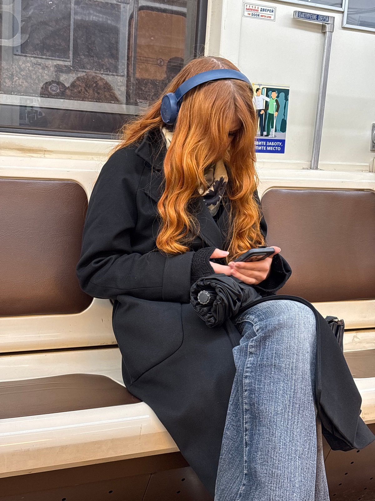Woman in blue headphones rides Saint Petersburg subway
