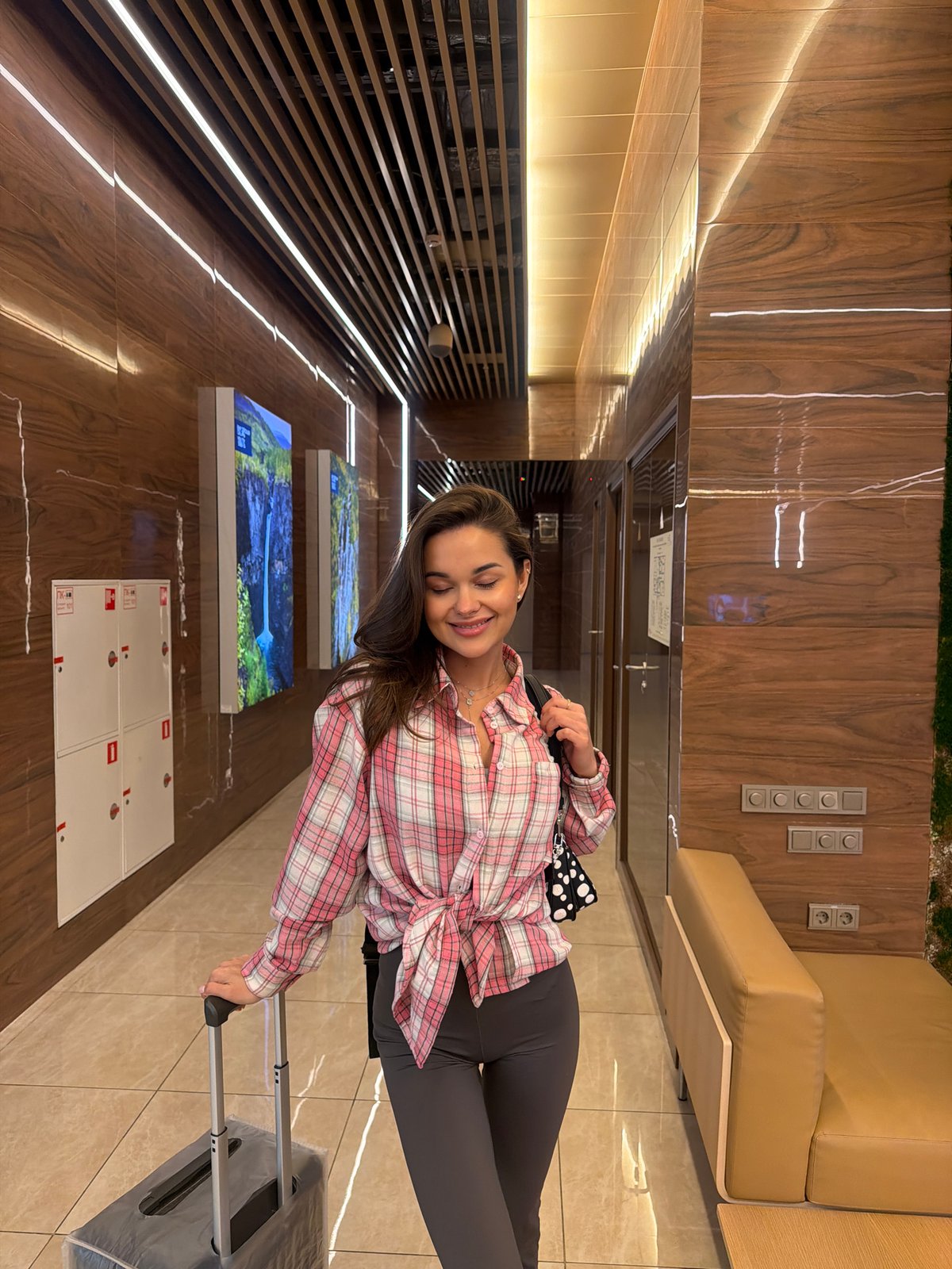 Woman travels with luggage, group photographed at Russian airport