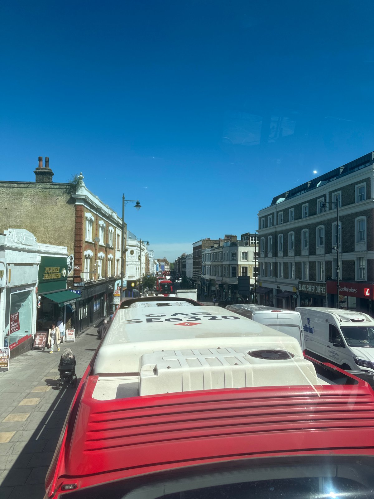 Sunny London street scene captured from elevated bus perspective