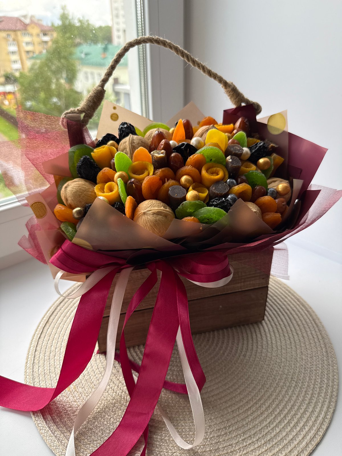 Person displays dried fruit bouquet in decorative wooden box