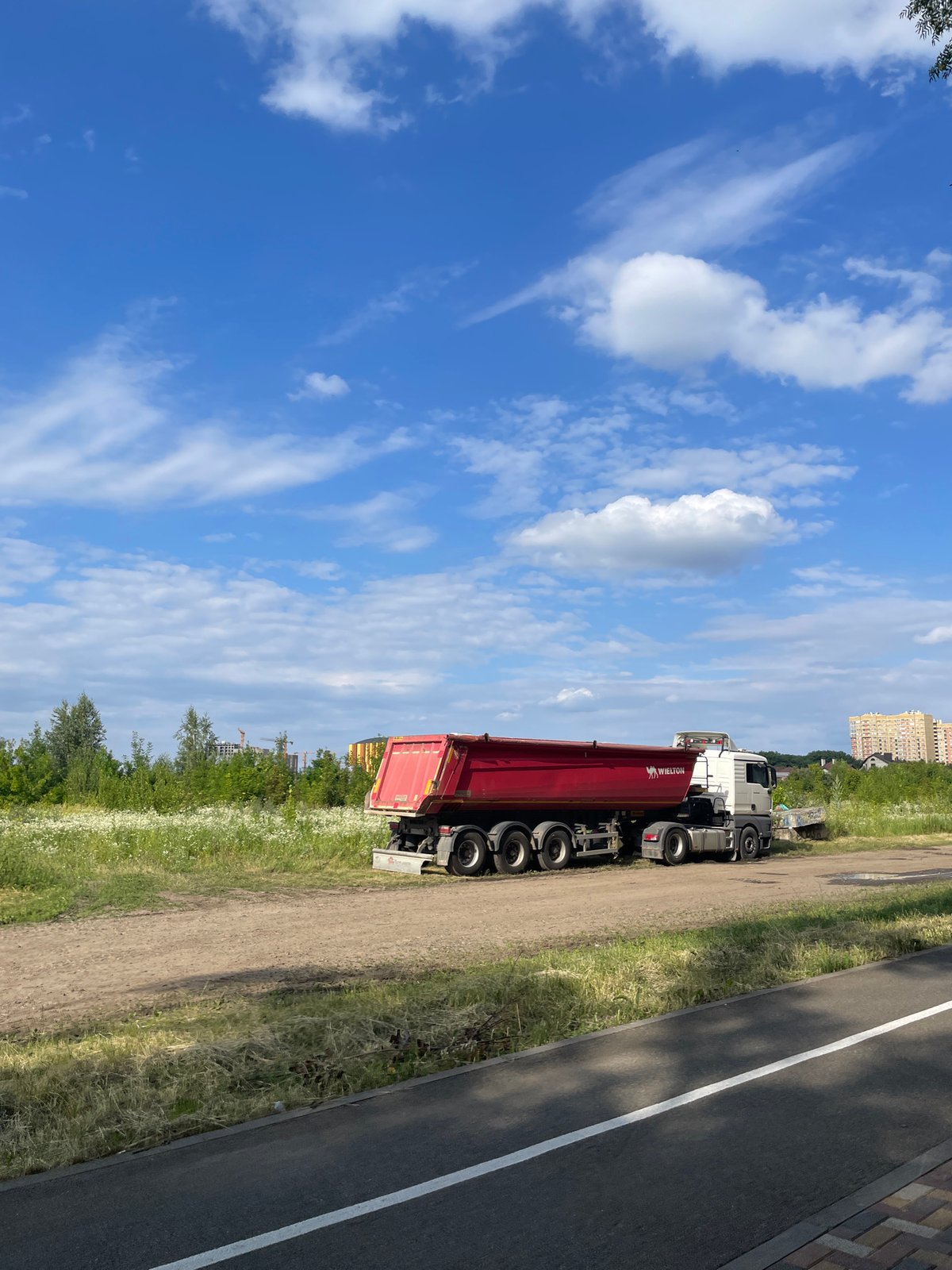 Stavropol park path meets active construction zone on a summer afternoon