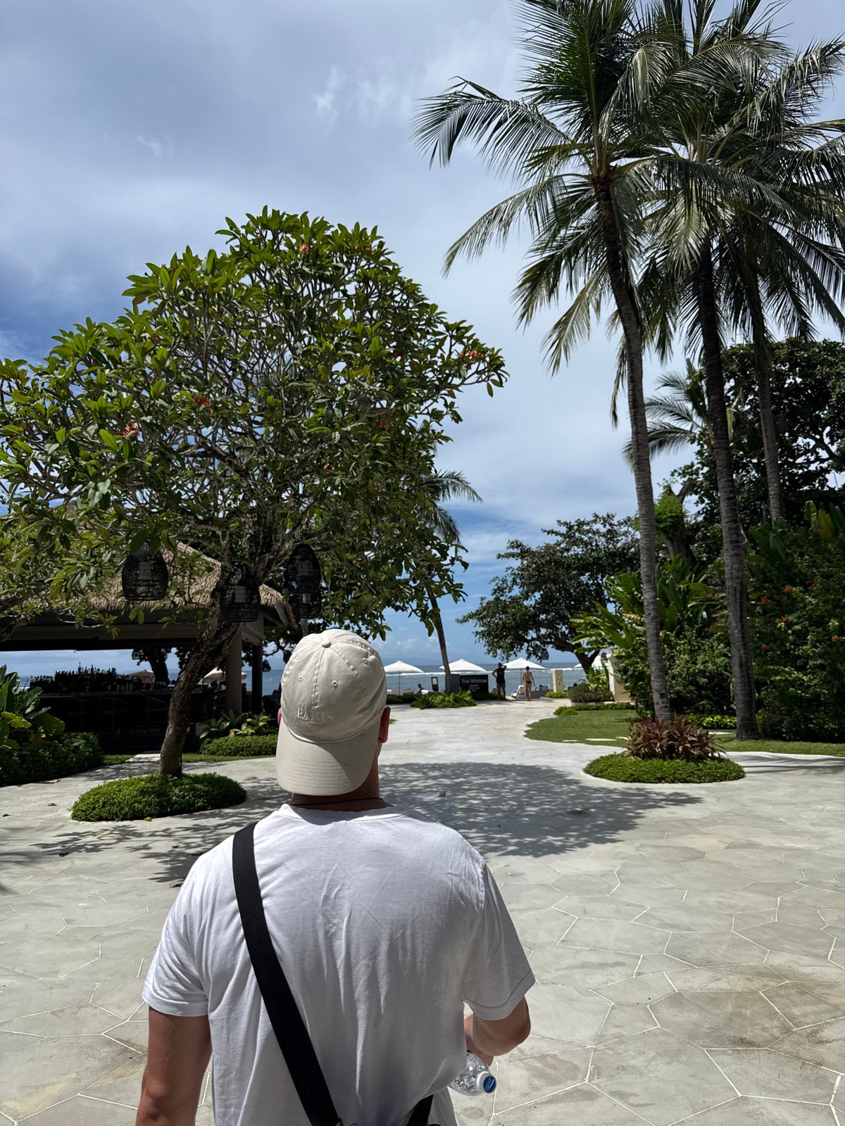 Tourist walks through resort areas in Kuta Selatan morning