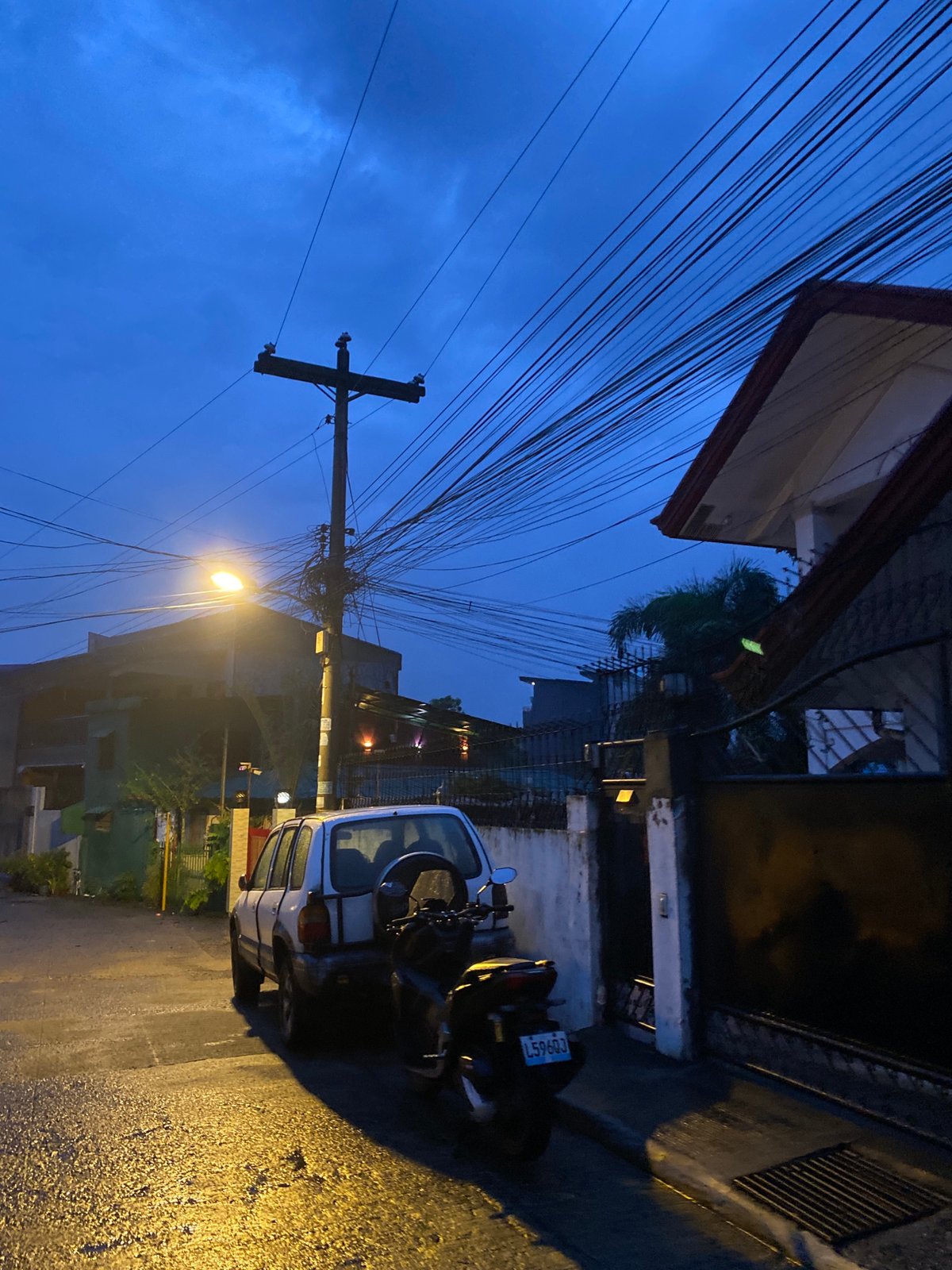 Wet streets and dusk light across a Davao City neighborhood