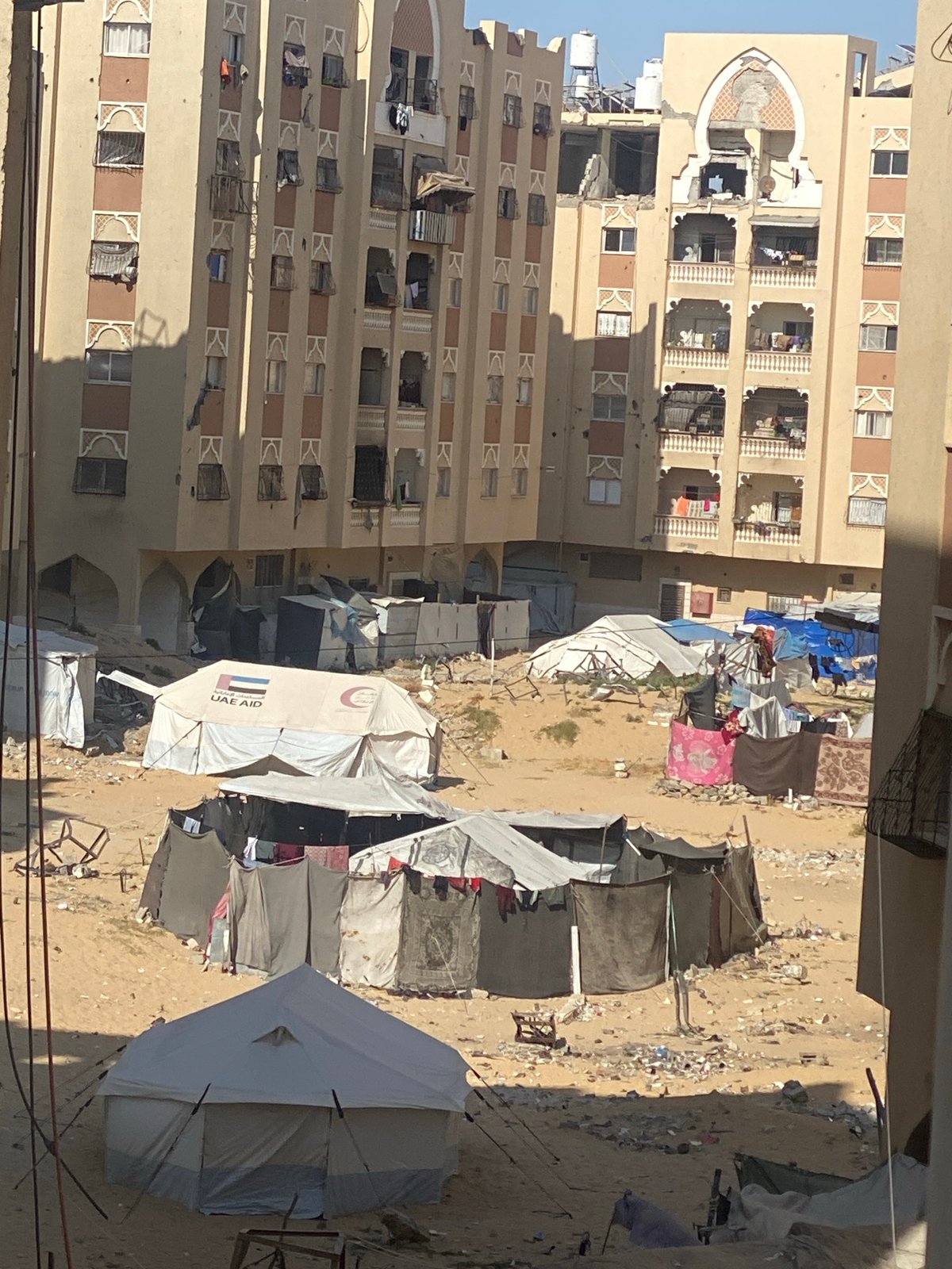 Temporary shelters documented near damaged building in Khan Yunis