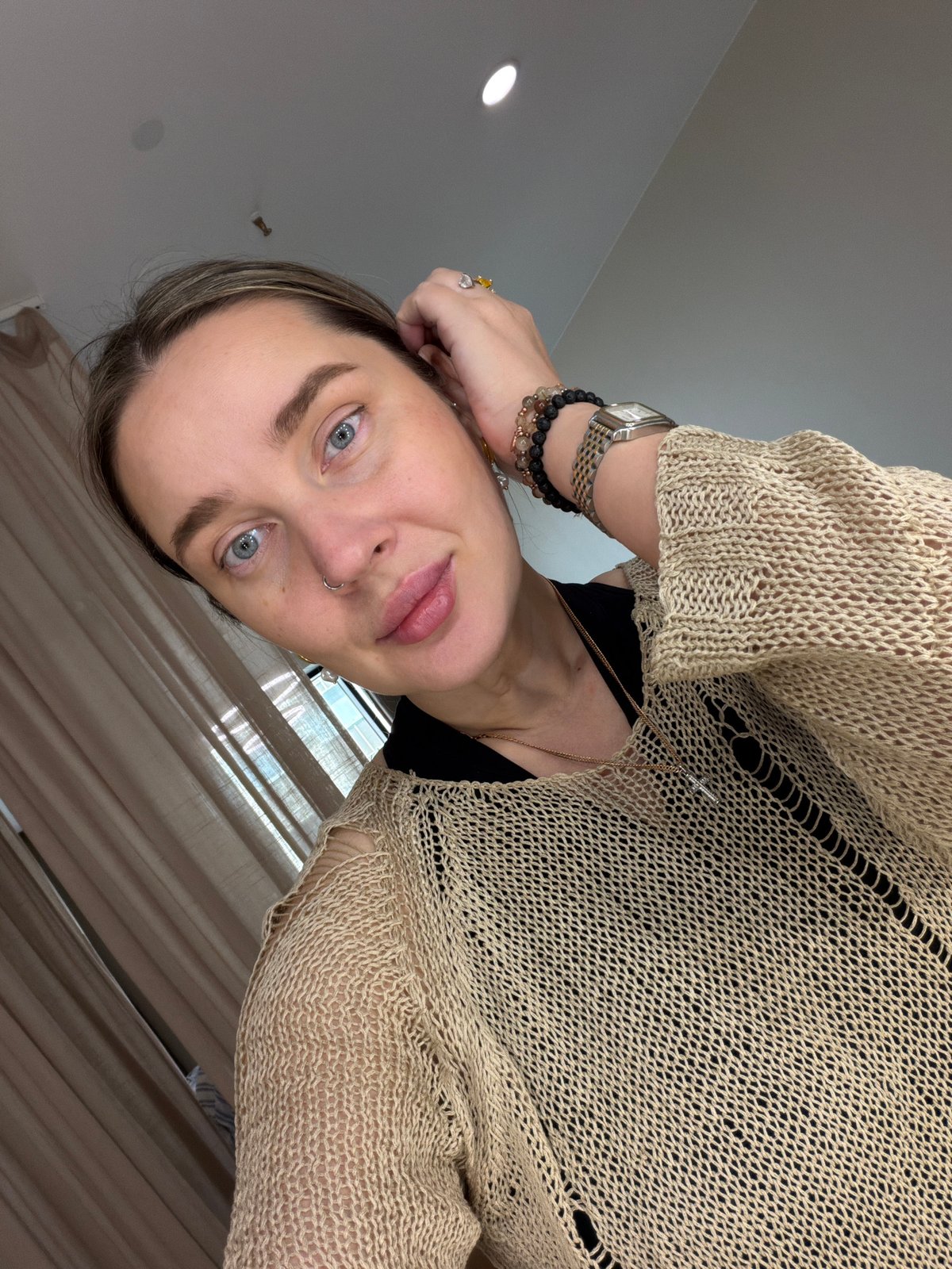 Woman in beige sweater observed wearing jewelry accessories