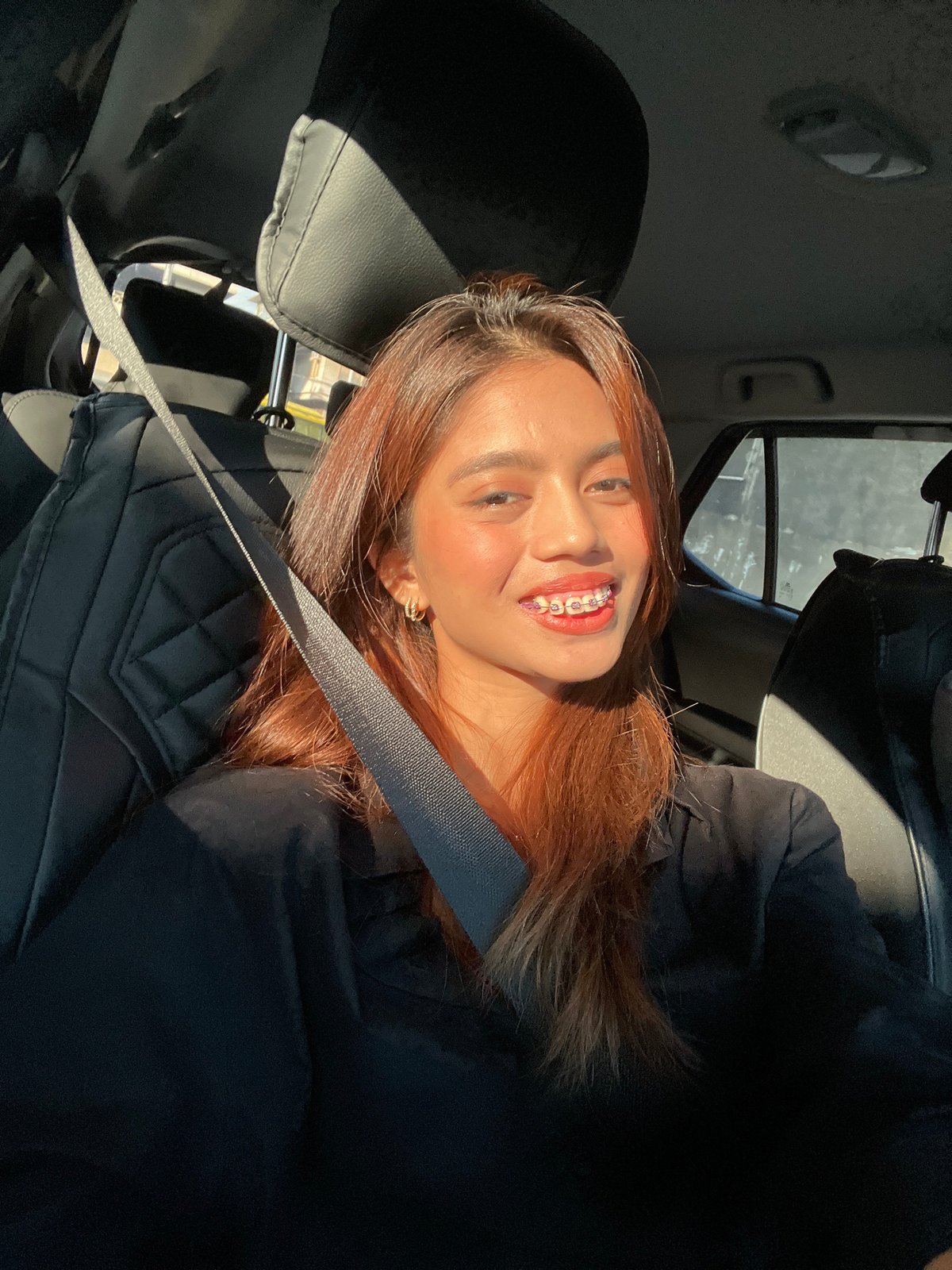 Woman takes selfies in car during morning drive