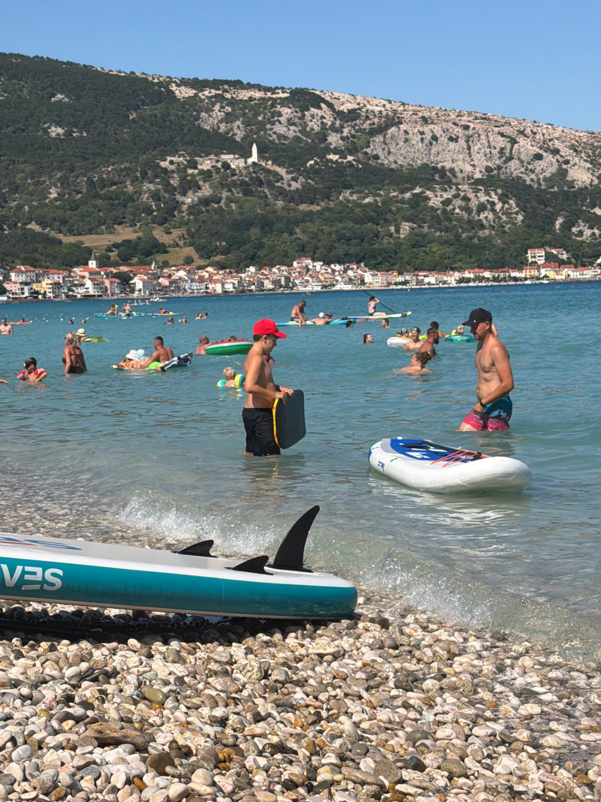 Crowded summer afternoon at Baška's pebble beach, Croatia