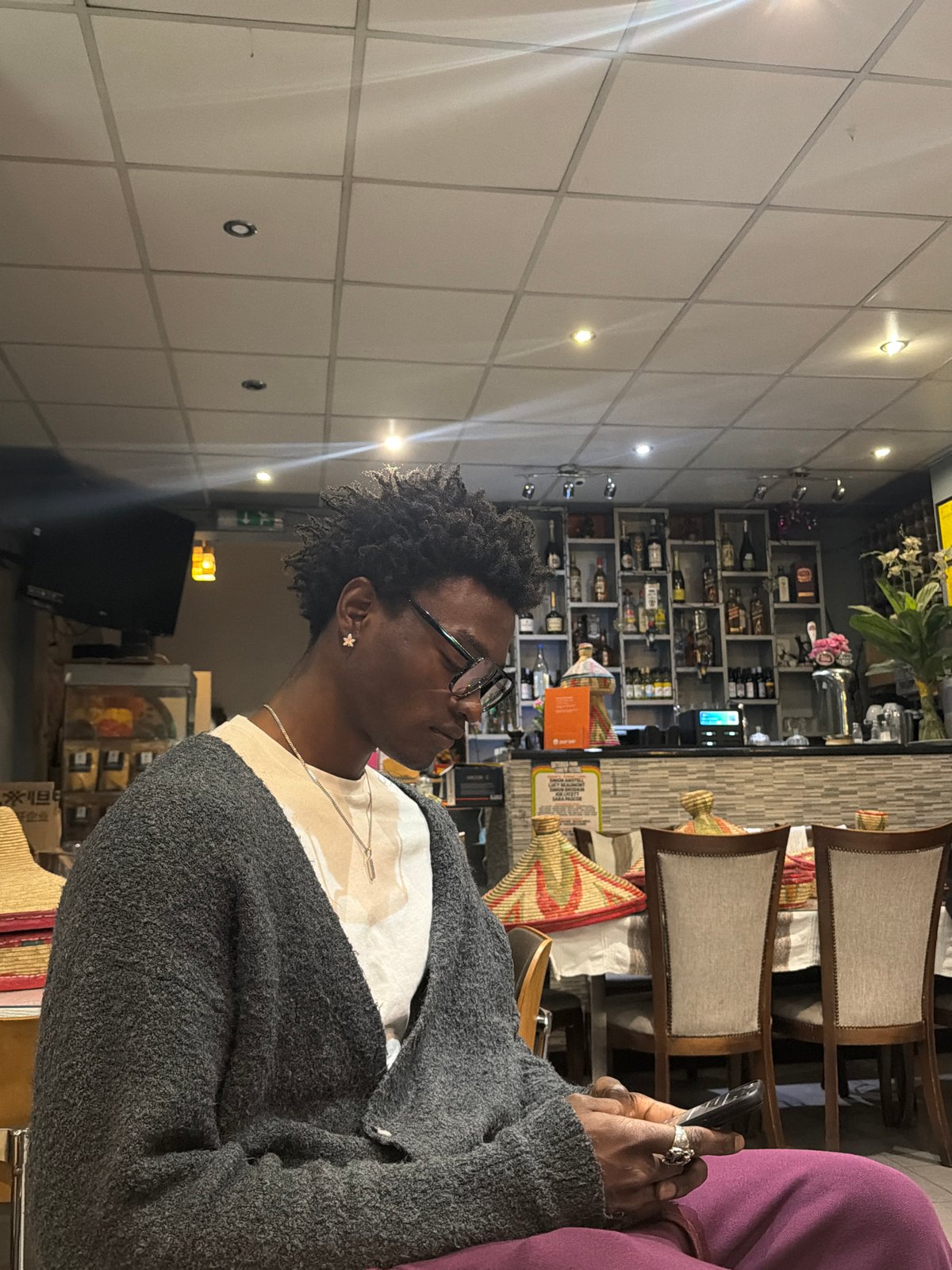 Person with flower earring photographed indoors in London