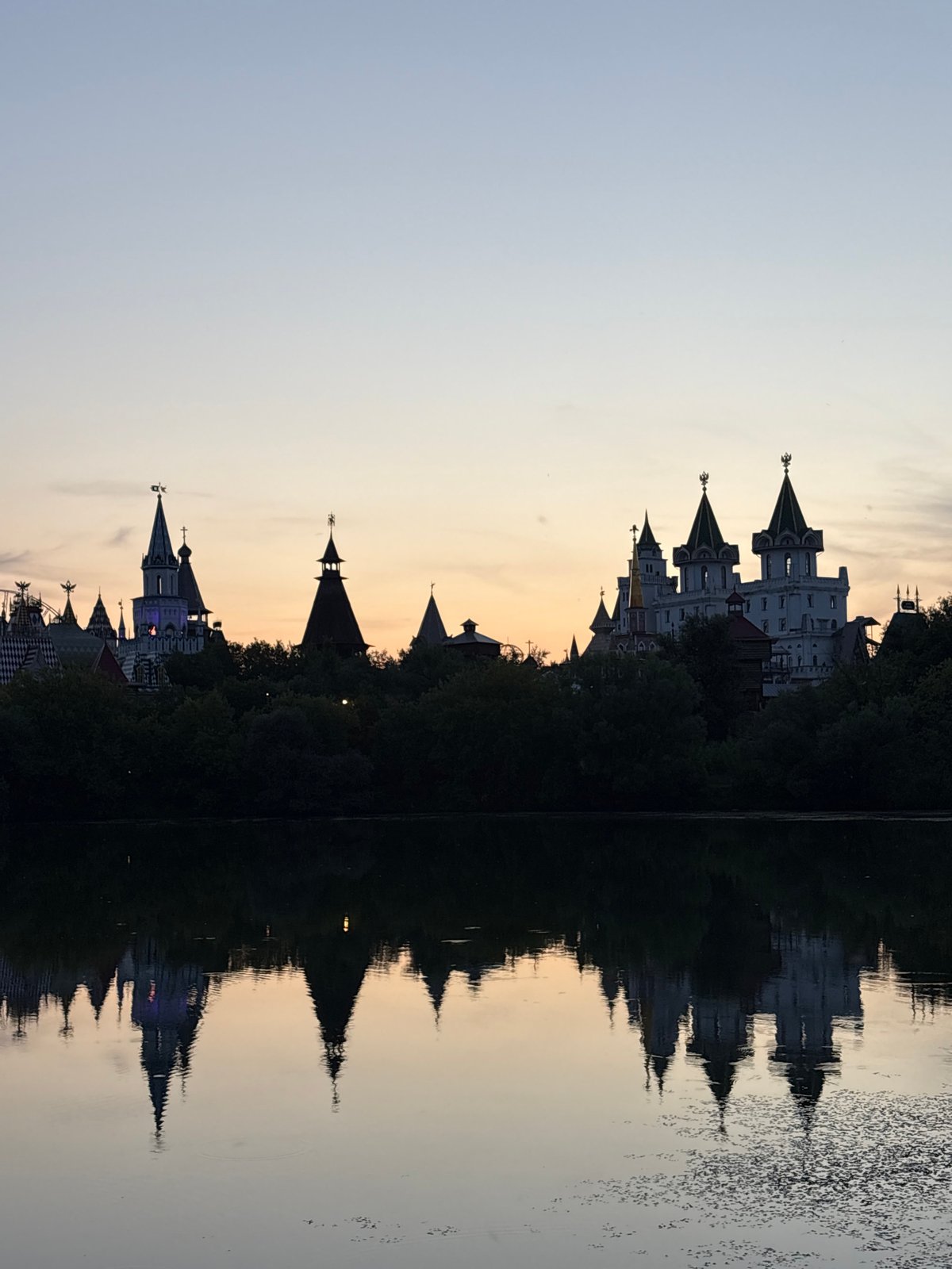 Evening on a Moscow river, towers reflecting and a canoe drifting past