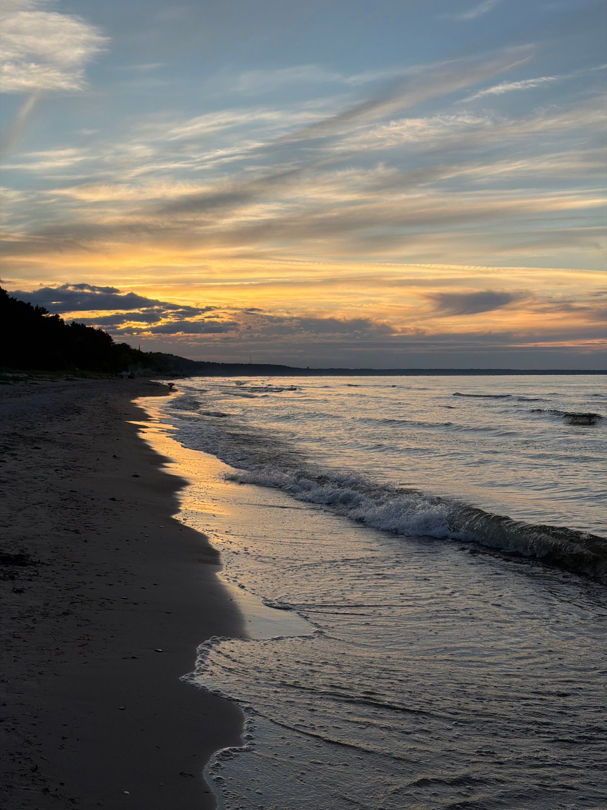Dusk settles over a dark sand beach in coastal Latvia