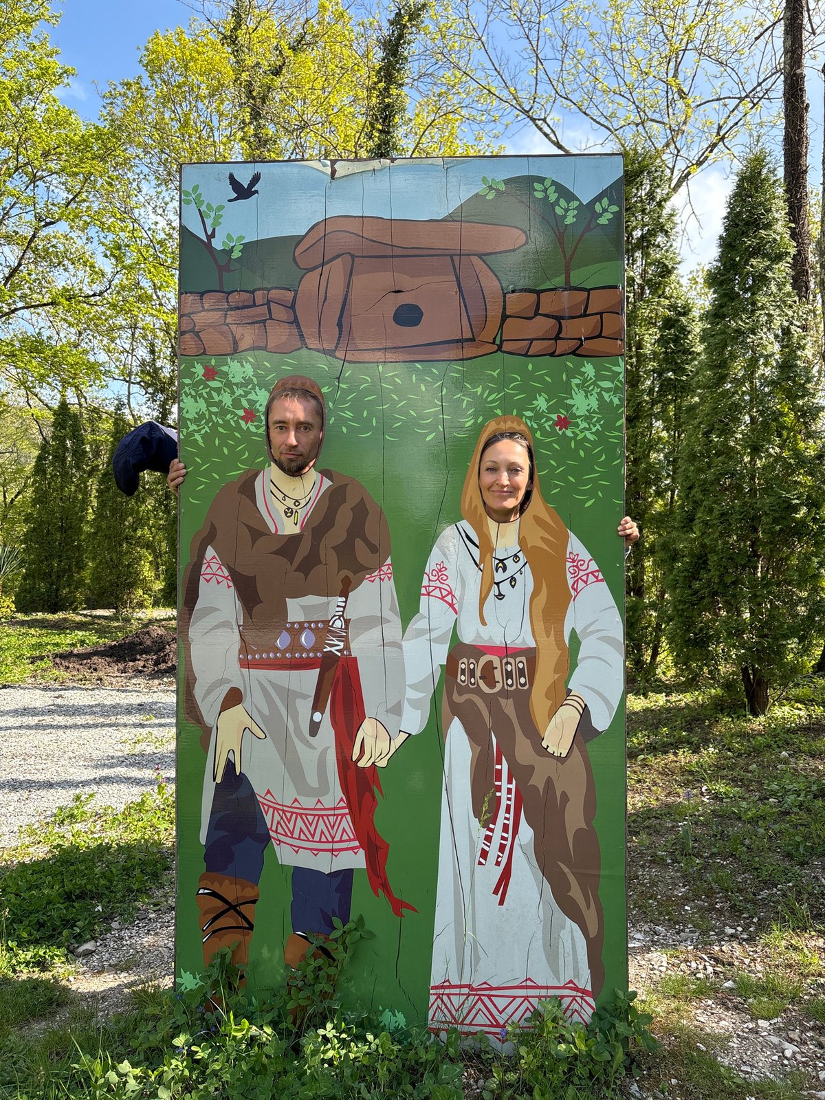 Tourists pose with folk costume cutout in Pshada