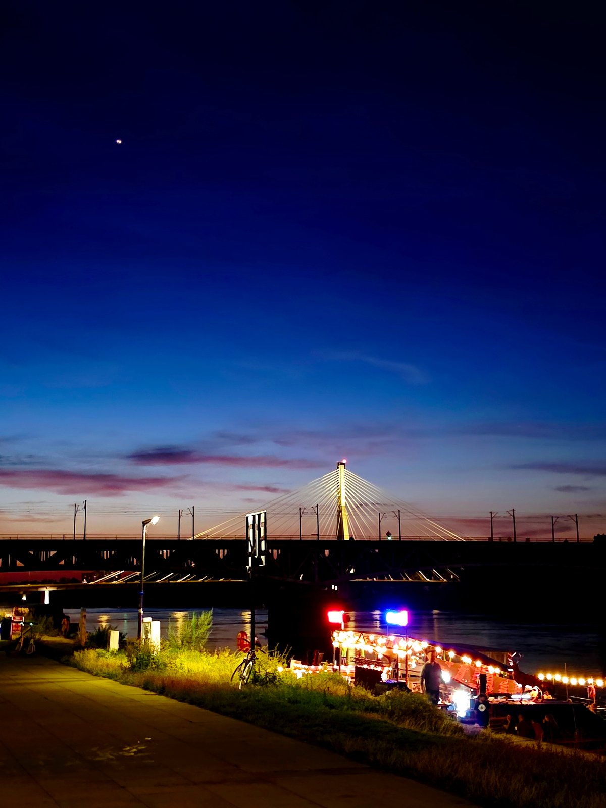 Świętokrzyski Bridge glowing over the Vistula at night