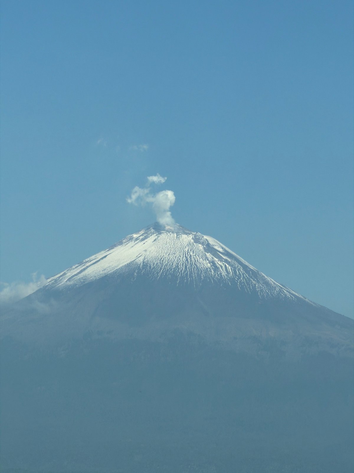 Snow-covered volcano emits smoke plume in Mexico