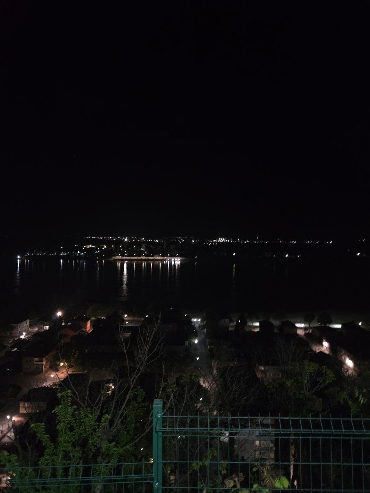 Nighttime water view captured from elevated position shows lights